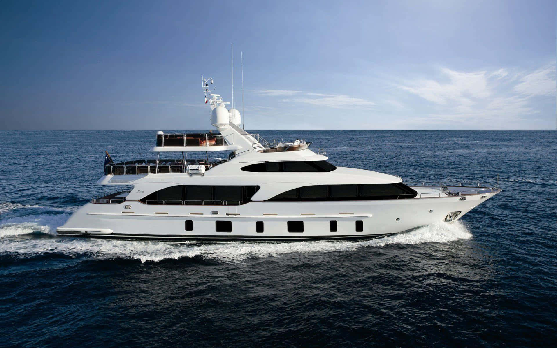 Yacht 桌布 壁紙 — 一艘時尚的白色豪華遊艇在晴朗的天空下劃過深藍色的海水，留下泡沫般的尾跡。