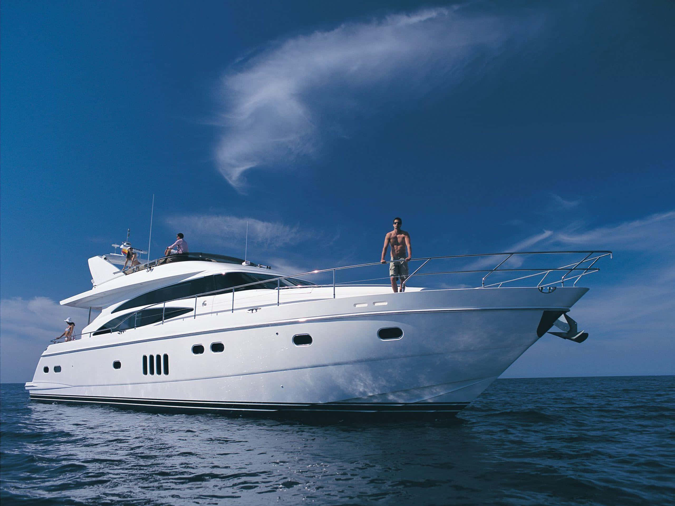 Yacht 桌布 壁紙 — 一艘時尚的白色豪華遊艇在深藍色海洋上滑行，天空明亮，雲朵輕柔。