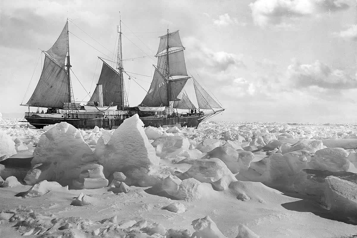 Antarctica 桌布 壁紙 — 一艘歷史帆船在多雲的天空下航行於崎嶇的浮冰原野中。