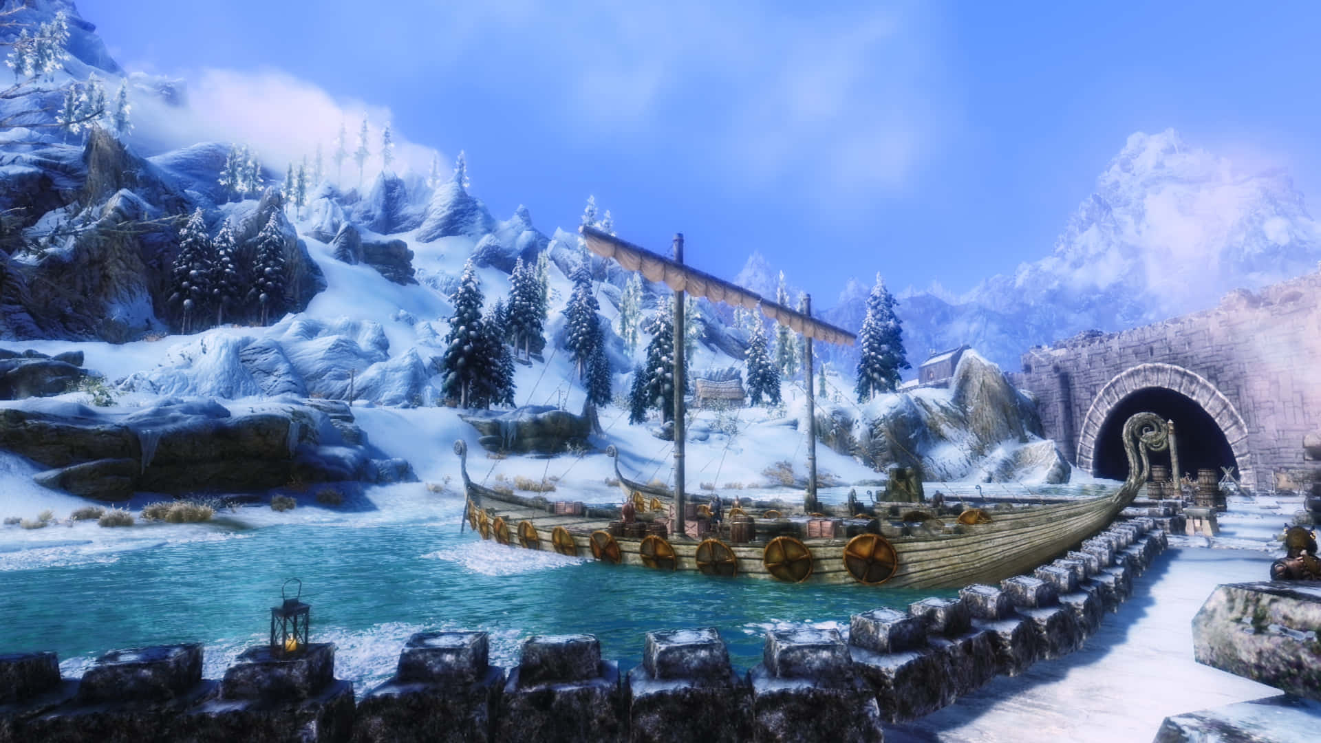 Skyrim Windhelm 桌布 壁紙 — 一艘維京長船停泊在冰冷的碧綠海水旁，石碼頭邊，背景是明亮的藍天、積雪的山峰和常青樹。