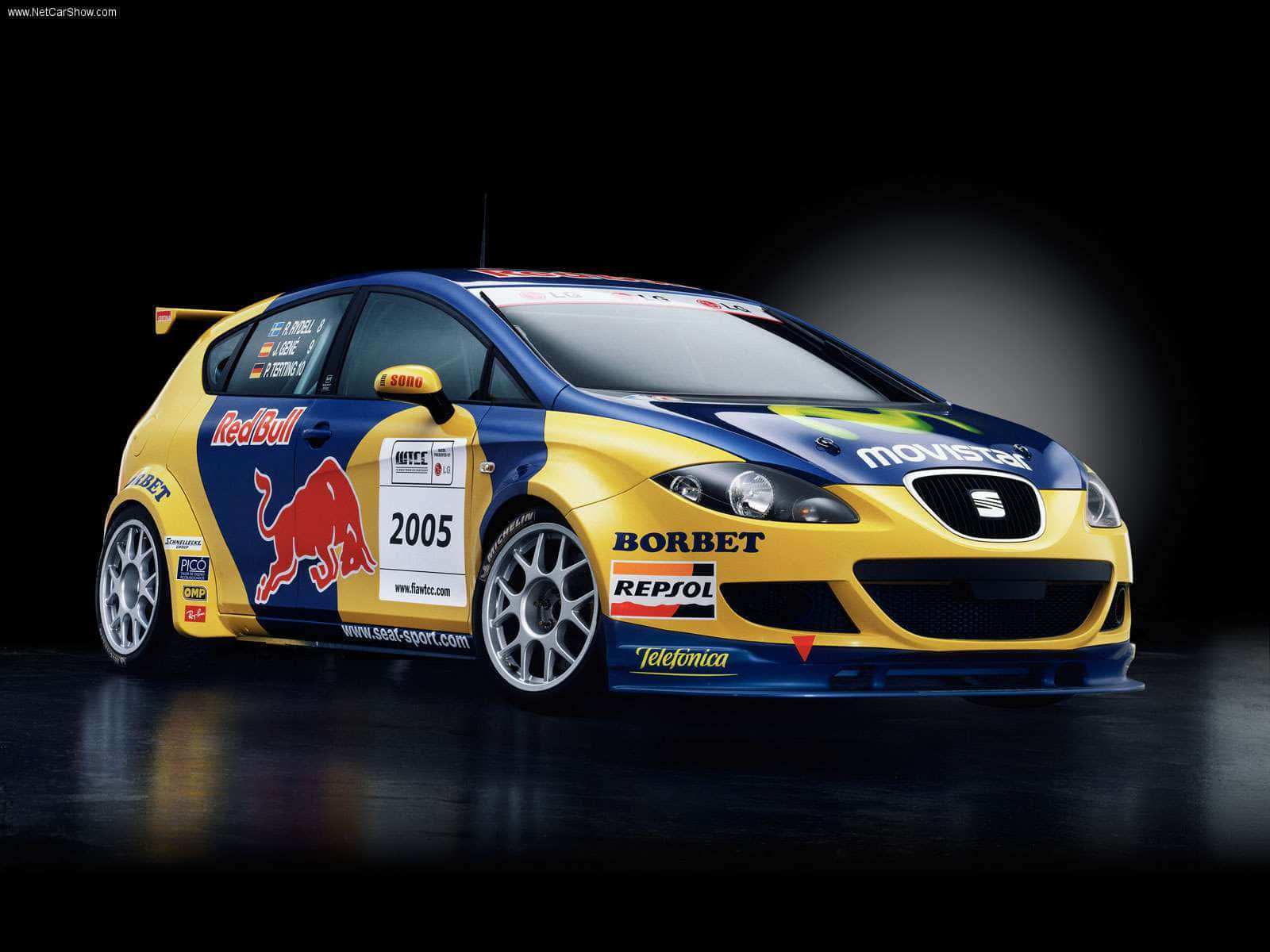 seat 桌布 壁紙 — 一輛2005年SEAT Leon Cupra賽車，採用鮮豔的黃藍配色，帶有Red Bull和Repsol標誌，在深色工作室背景下戲劇性地擺拍。