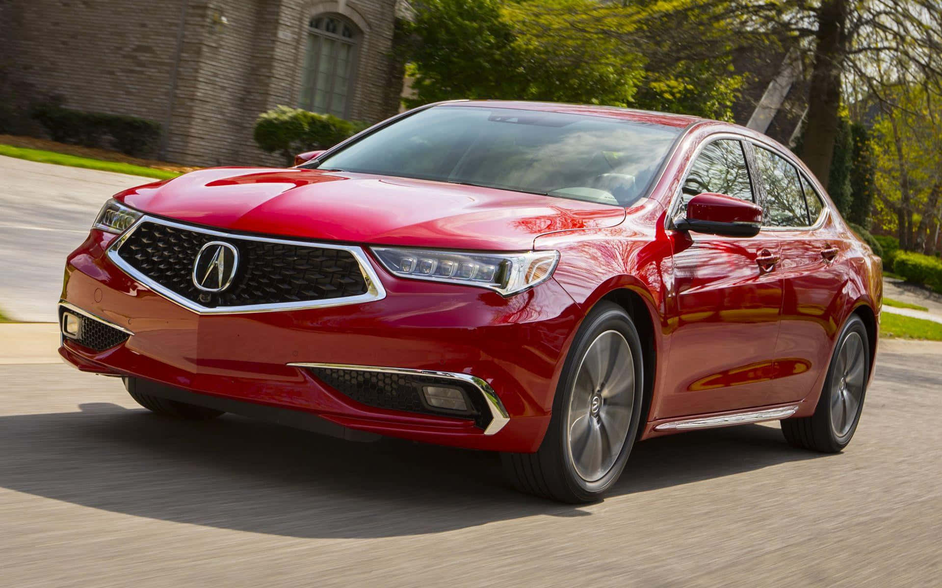 Acura Tlx 桌布 壁紙 — 一輛亮紅色Acura轎車在明亮的日光下，以模糊的動態行駛在郊區街道上。