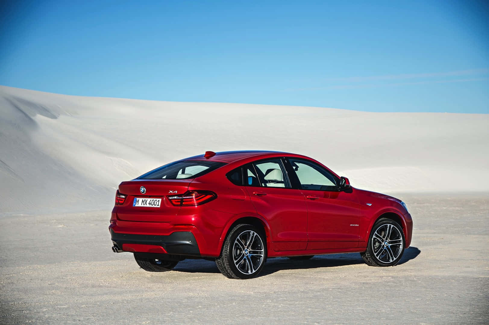Bmw X4 桌布 壁紙 — 一輛亮紅色BMW X4 SUV停泊在廣闊的白色沙丘上，天空清澈湛藍。