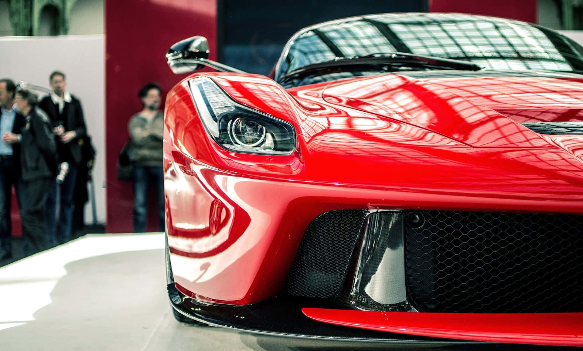 Ferrari Laferrari 桌布 壁紙 — 一輛亮紅色法拉利跑車的特寫，展示中，背景有人觀看。