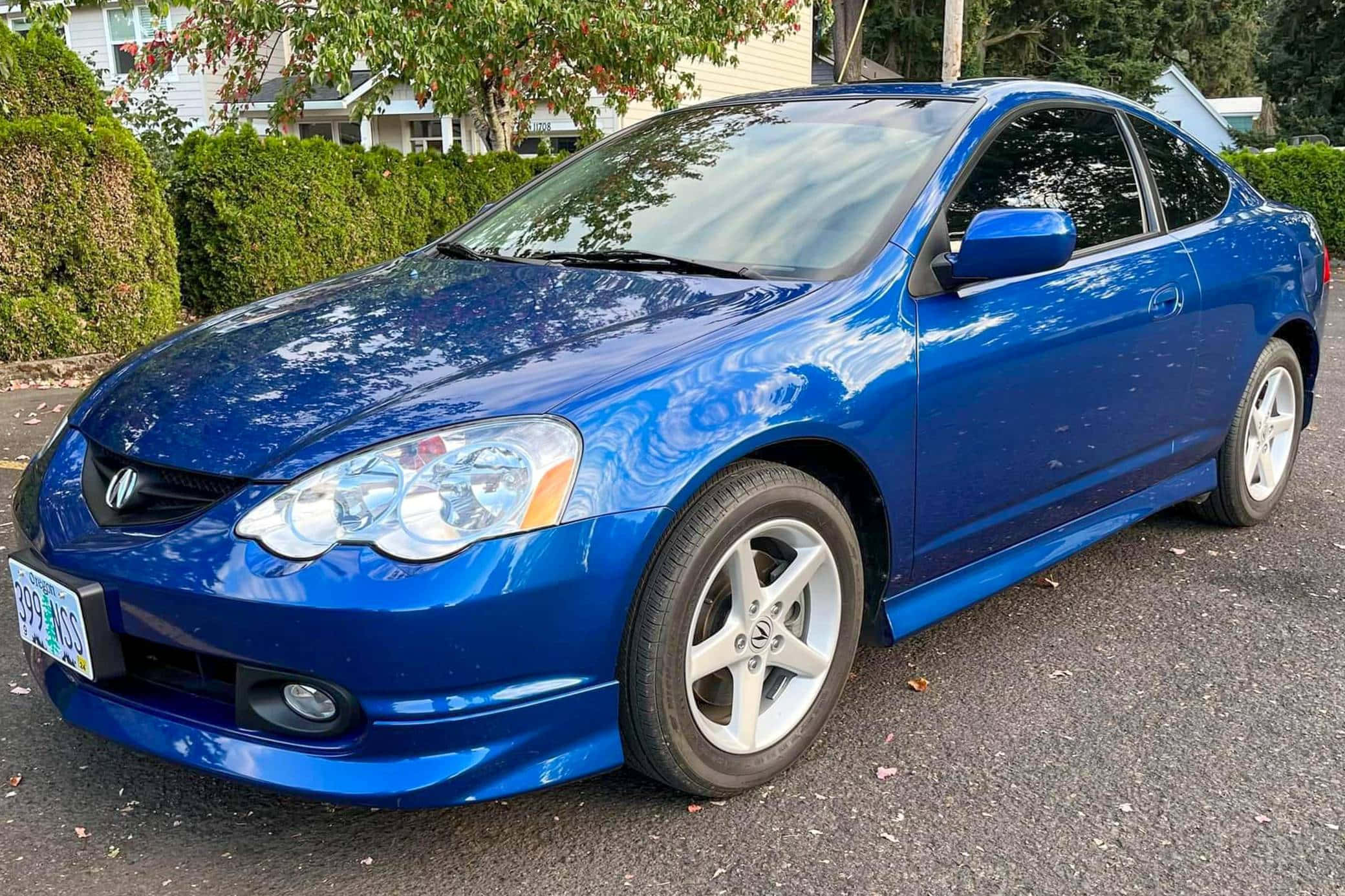 Acura Rsx 桌布 壁紙 — 一輛亮藍色本田轎跑車停在瀝青路上，背景有樹木和房屋。