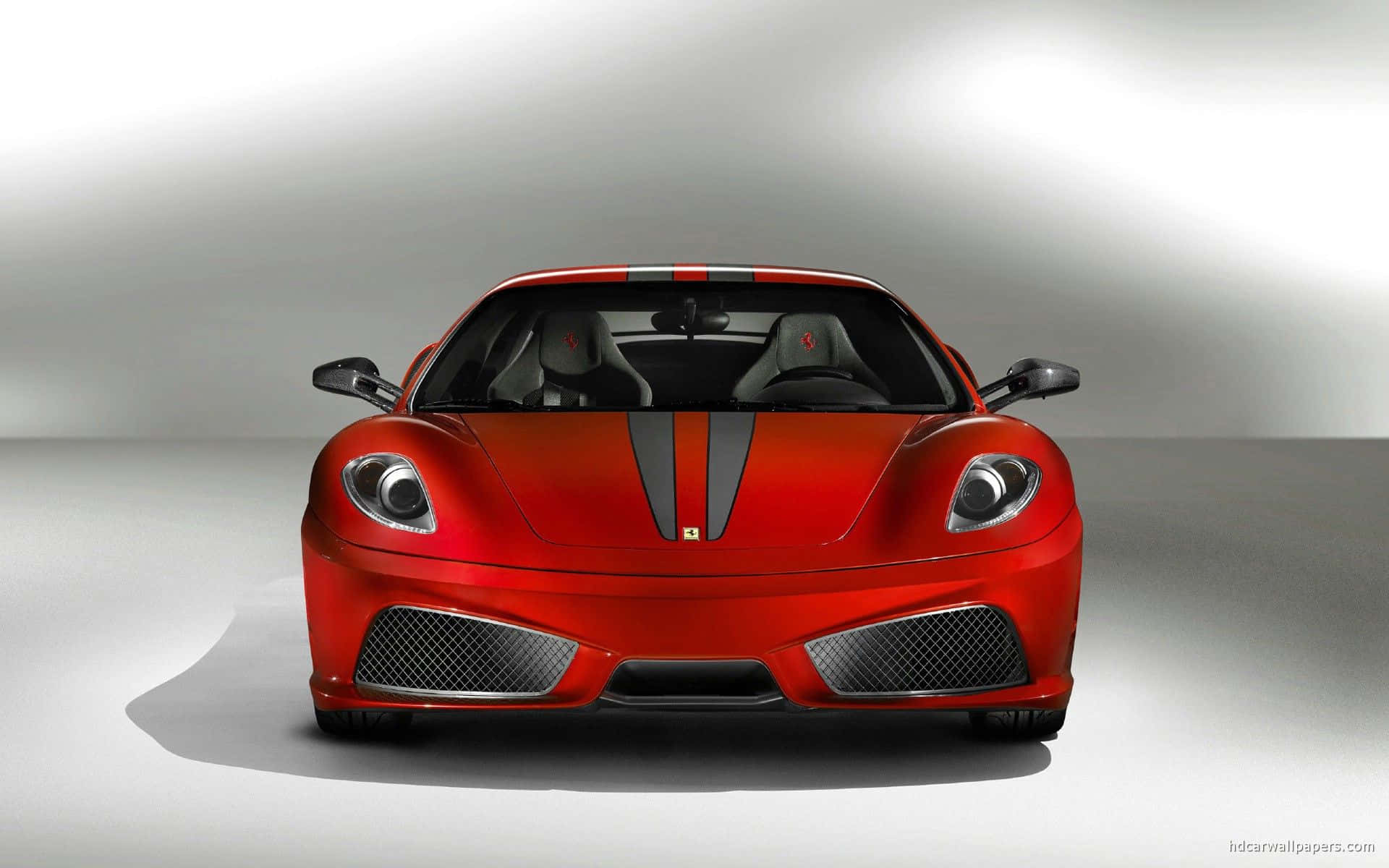 Ferrari F430 桌布 壁紙 — 一輛亮面紅色法拉利跑車帶有黑色賽車條紋，在簡約的攝影棚場景中正面朝前。