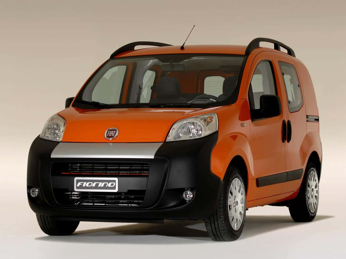 Fiat Fiorino 桌布 壁紙 — 一輛充滿活力的橙色 Fiat Fiorino 緊湊型貨車，帶有黑色飾邊和車頂架，在乾淨的攝影棚環境中拍攝。