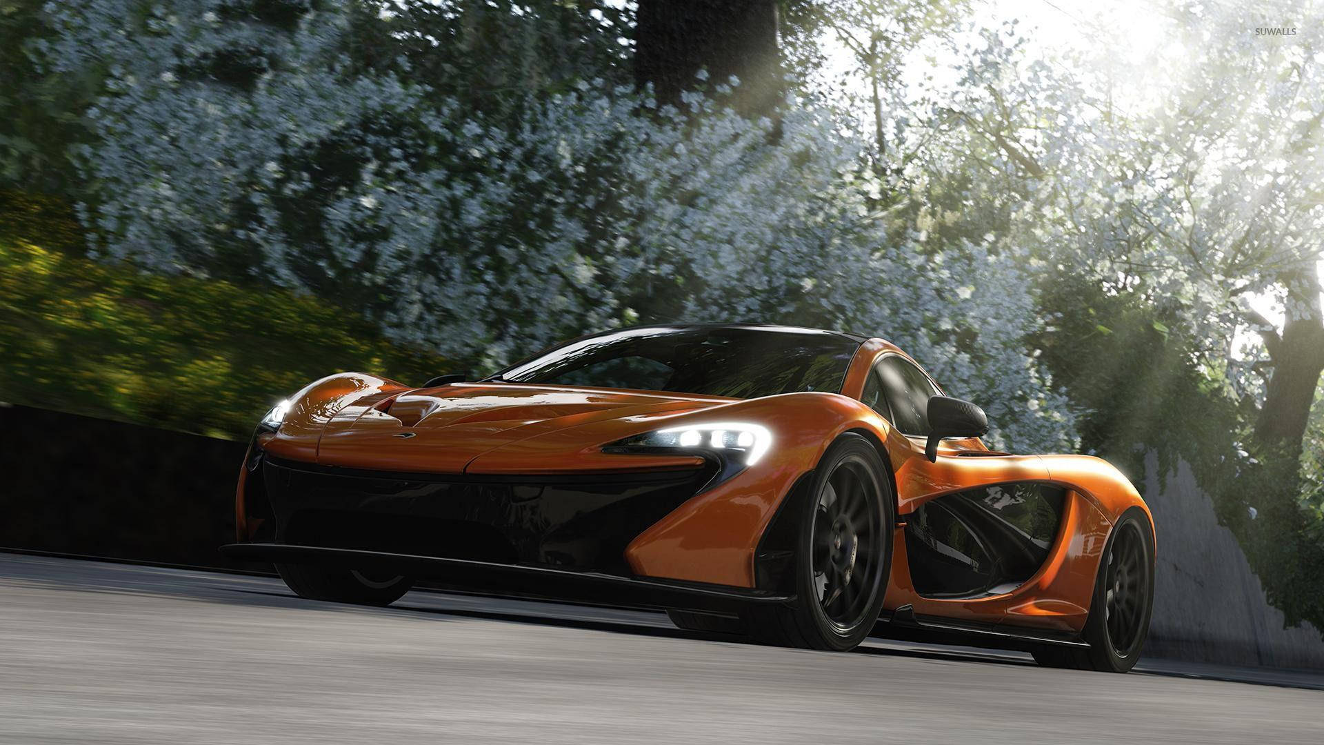 遊戲 桌布 壁紙 — 一輛充滿活力的橙色McLaren P1超級跑車在陽光明媚的道路上飛馳，兩旁是盛開的白色樹木和茂密的綠色植物。