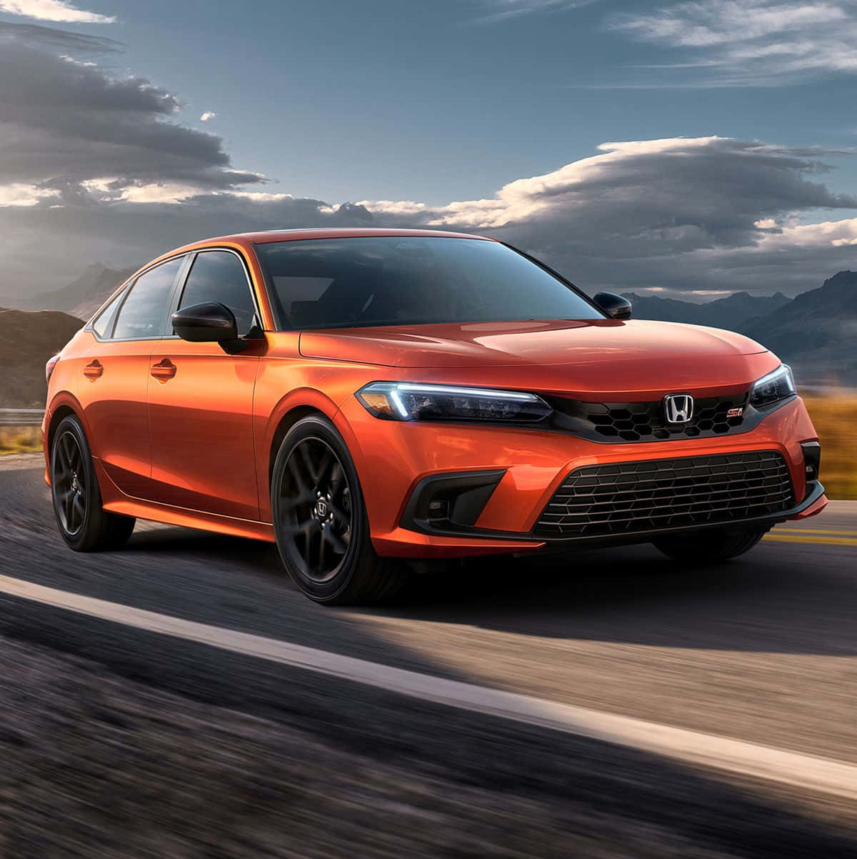 Honda Civic 桌布 壁紙 — 一輛充滿活力的橙色本田思域Type R在戲劇性的多雲天空下沿著山路飛馳。