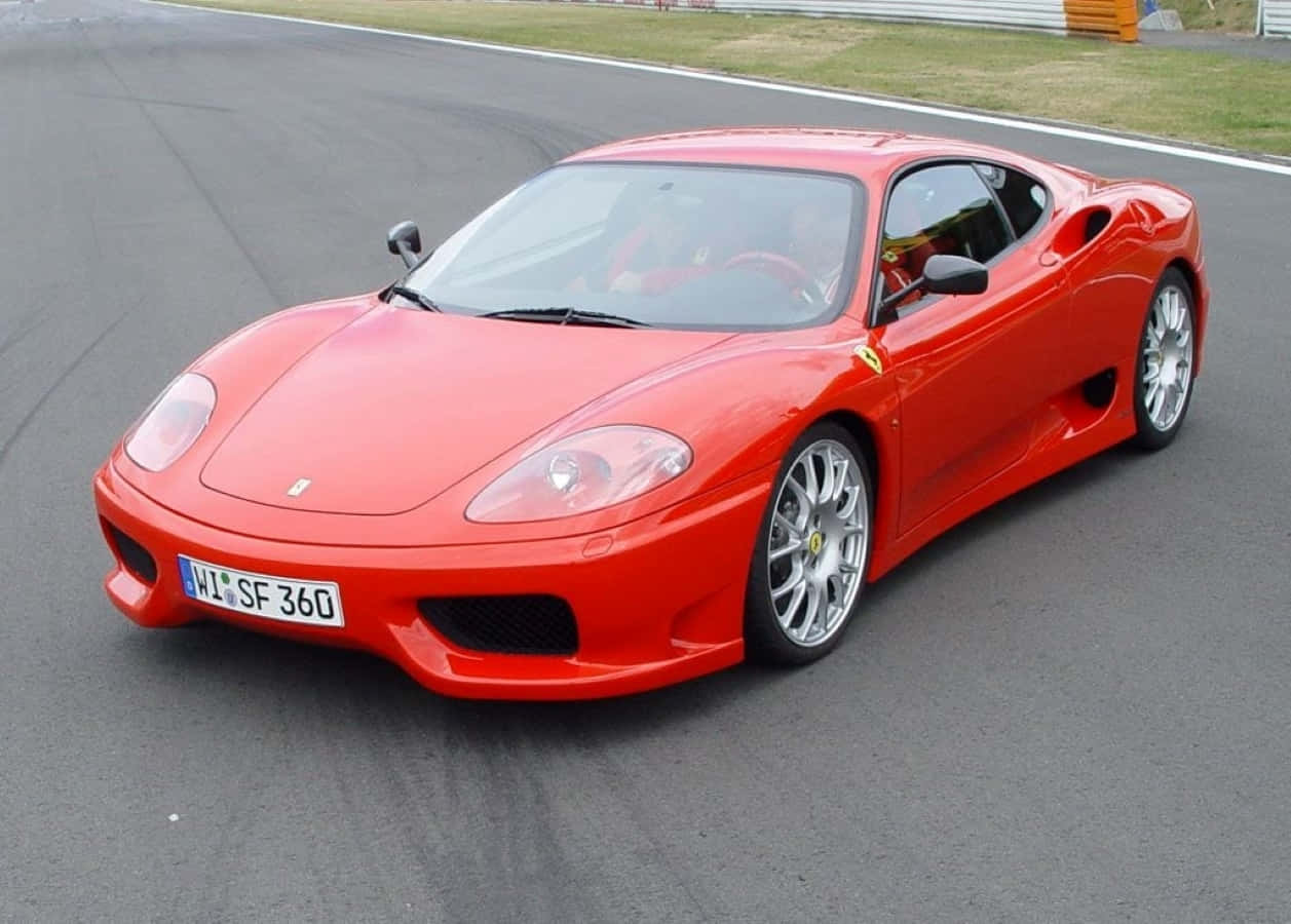 Ferrari 360 Modena 桌布 壁紙 — 一輛充滿活力的紅色法拉利SF360跑車精準而強勁地沿著賽道滑行。