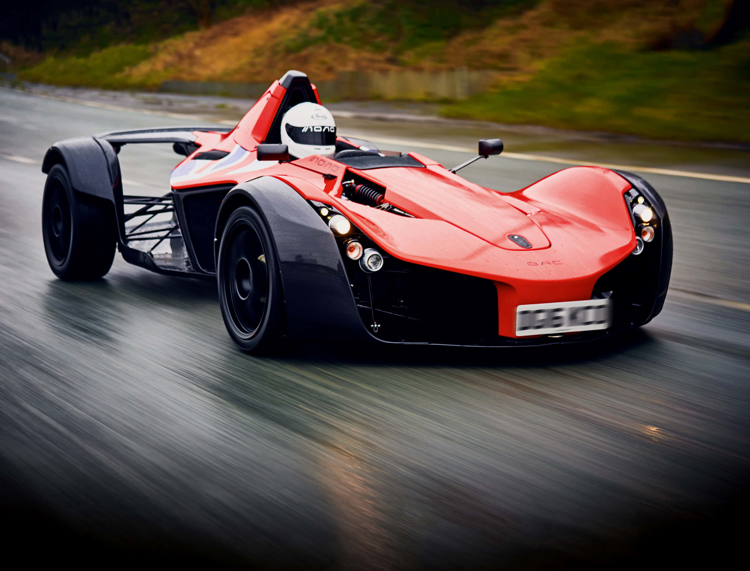 Car Racing 桌布 壁紙 — 一輛充滿活力的紅黑開輪跑車在潮濕的道路上疾馳，動態模糊傳達出高速感。