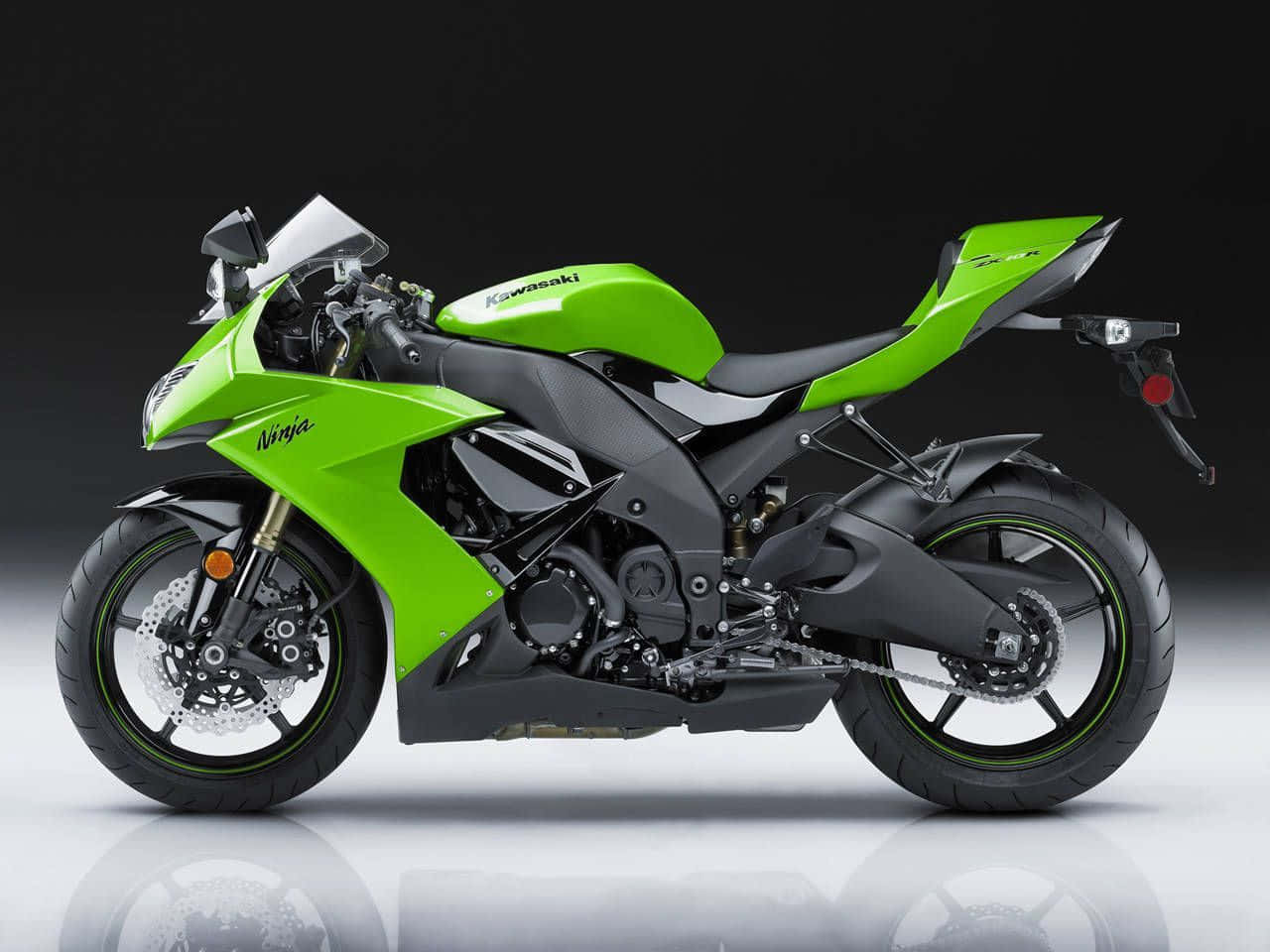 機車 桌布 壁紙 — 一輛充滿活力的綠色Kawasaki Ninja運動電單車，帶有黑色點綴和鍍鉻細節，在黑暗背景下立於反射的攝影棚地板上。