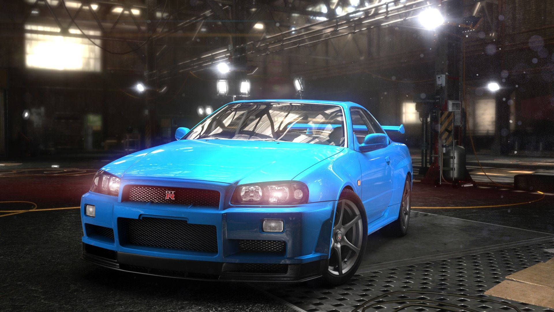 Nissan Skyline GTR R34 The Crew 壁紙 — 一輛充滿活力的藍色日產Skyline GT-R在明亮的車庫燈光下，在金屬網格地板上閃閃發光。