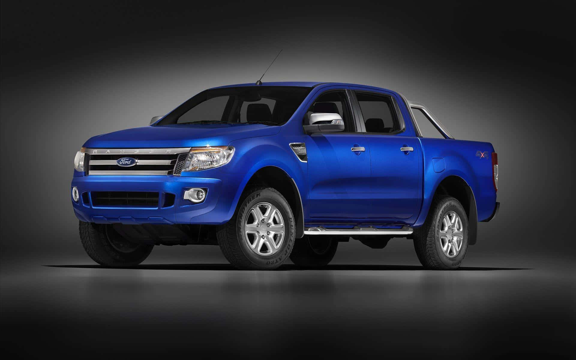 Ford Ranger 桌布 壁紙 — 一輛充滿活力的藍色福特 Ranger 皮卡車在工作室環境中展示，配有戲劇性的燈光和深色漸變背景。