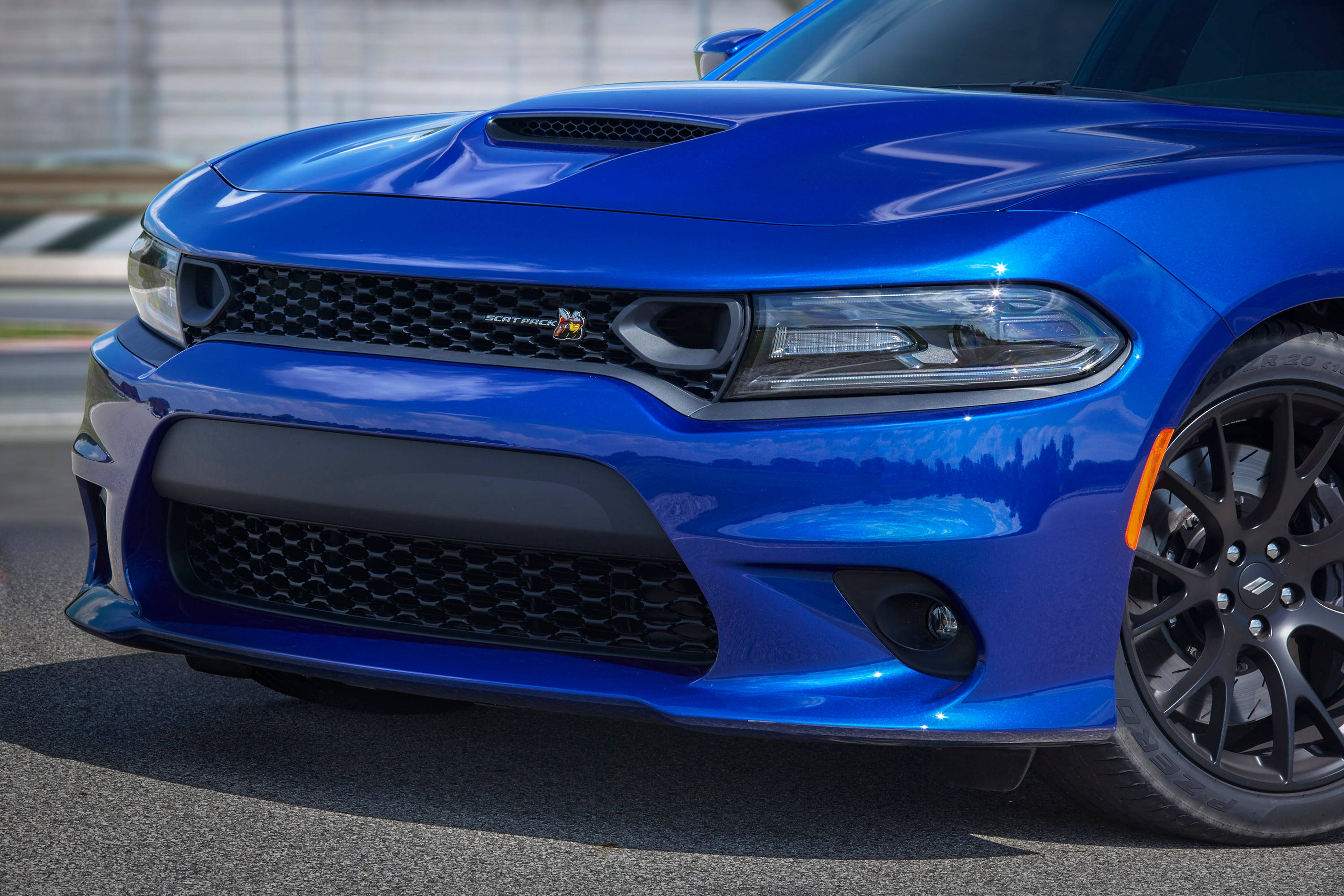 Mopar 2019 Dodge Charger Scat Pack 壁紙 — 一輛充滿活力的藍色道奇挑戰者SRT Hellcat，帶有黑色飾邊和橙色點綴，停在陽光普照的瀝青路面上。