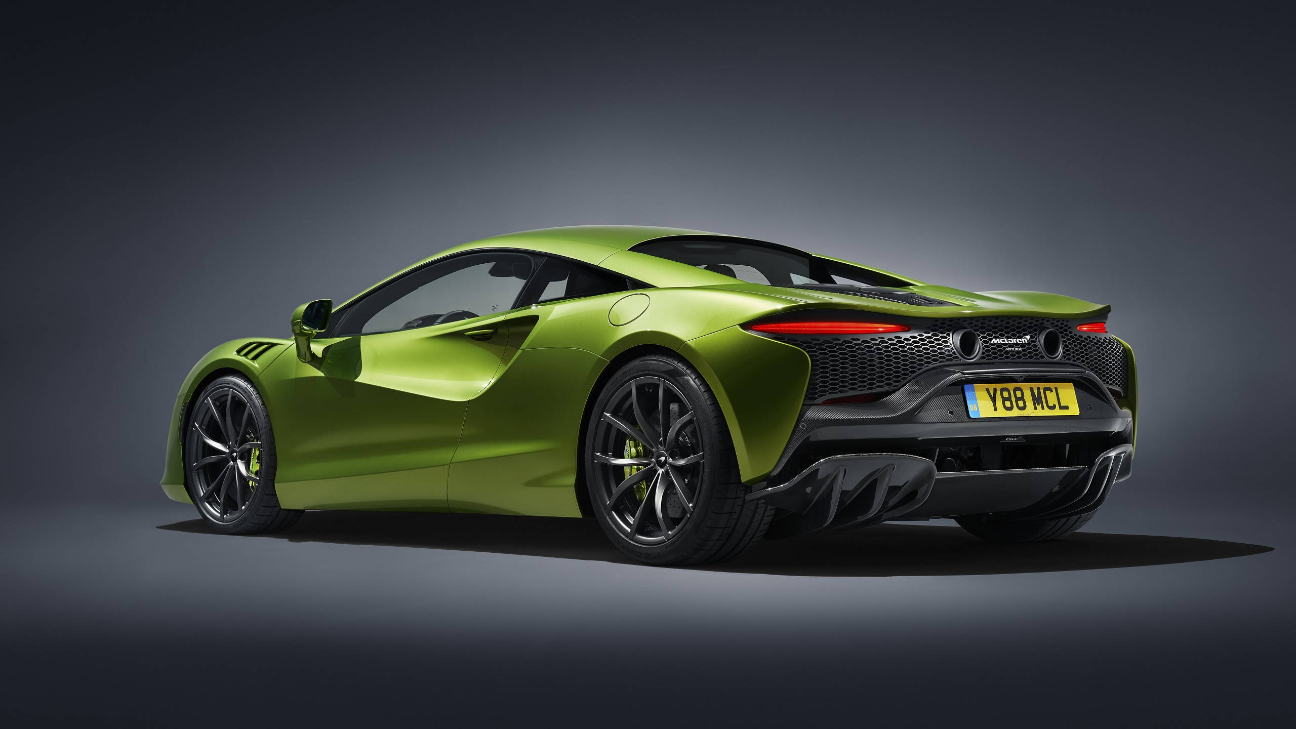 Sports Car 桌布 壁紙 — 一輛充滿活力的青檸綠色McLaren跑車在攝影棚內以戲劇性燈光和深灰色背景展示。