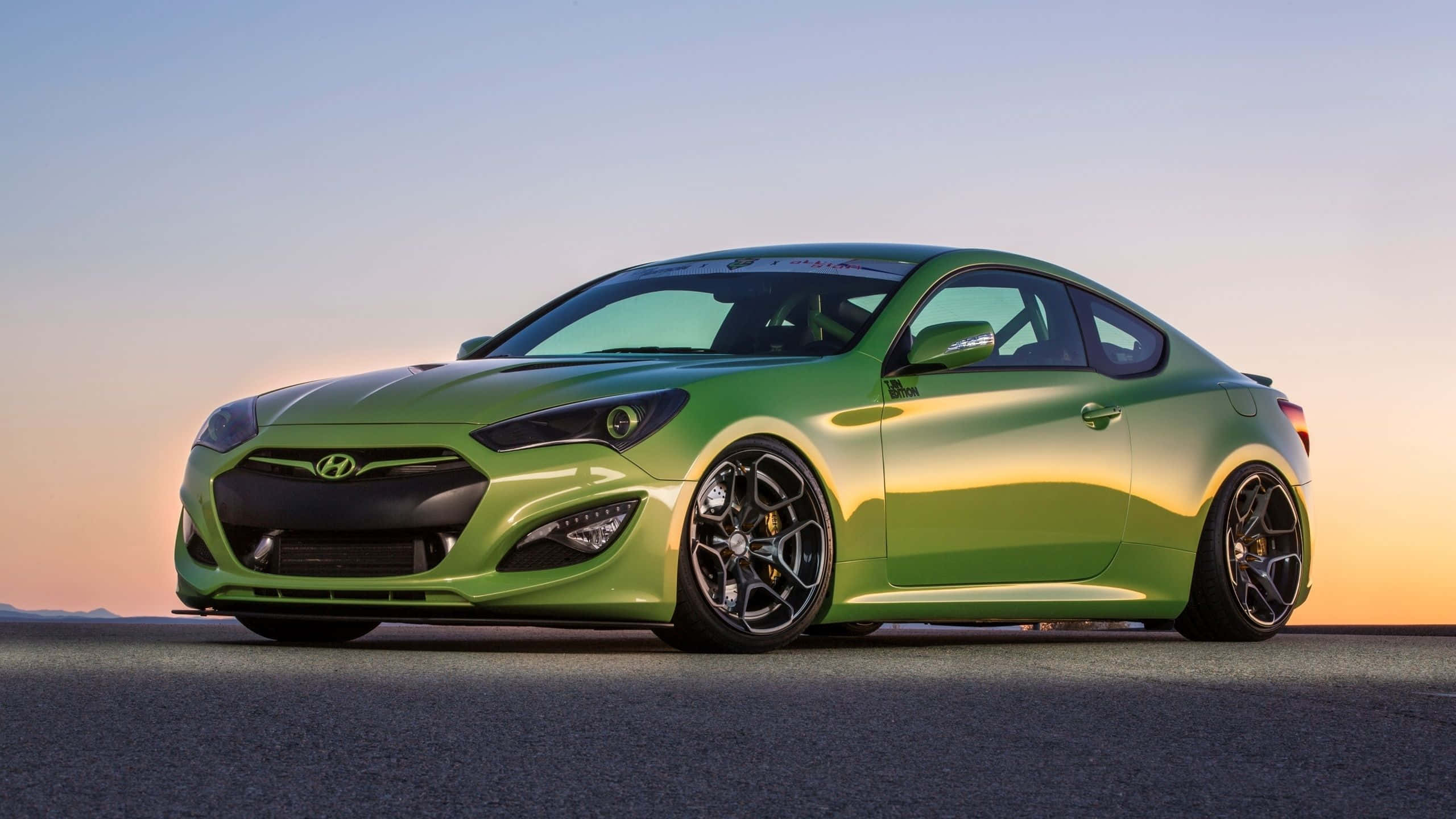 Hyundai Genesis 桌布 壁紙 — 一輛充滿活力的青檸綠色跑車在柔和的日落天空下，在開闊的瀝青路上閃閃發光。