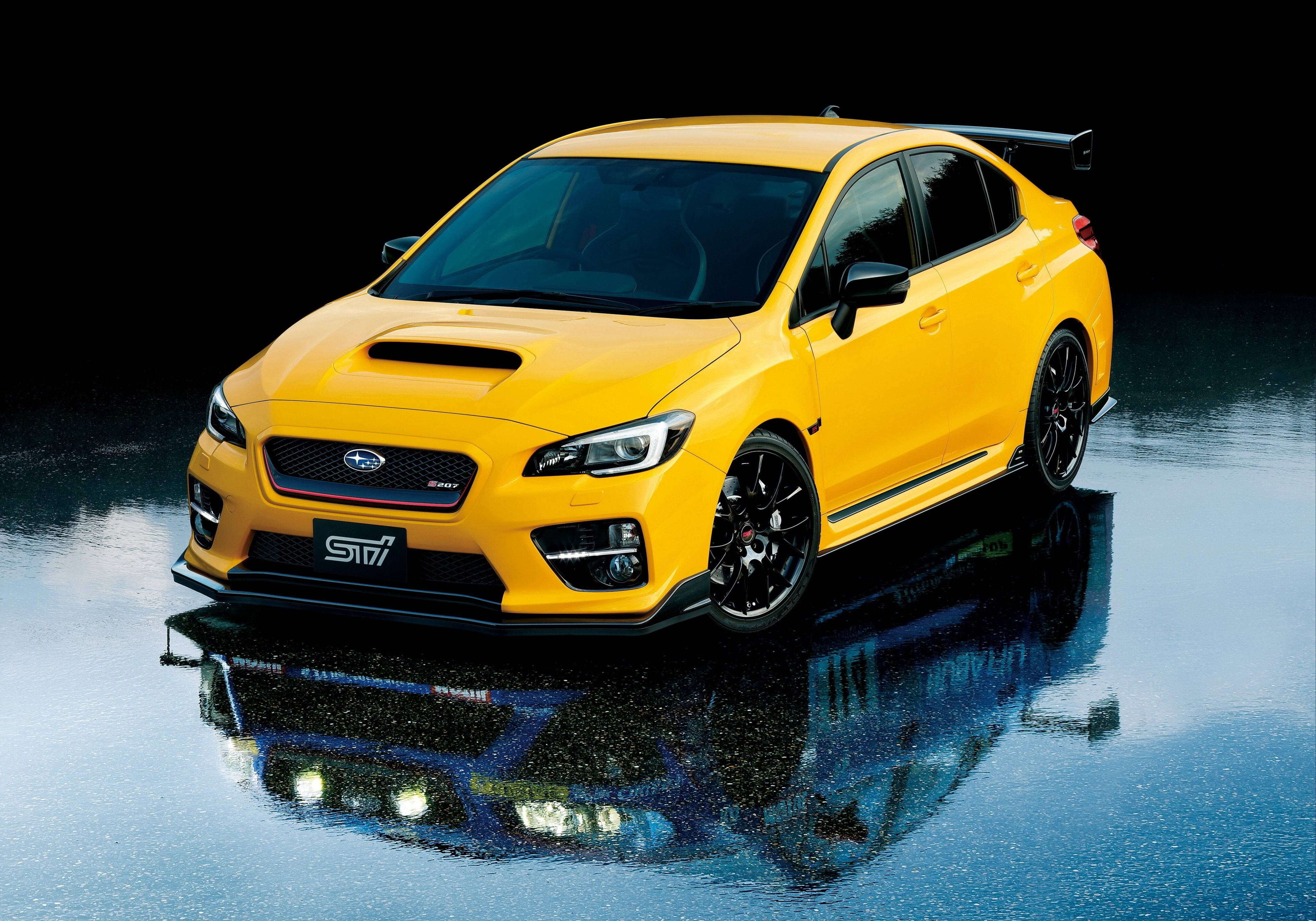 Sports Car 桌布 壁紙 — 一輛充滿活力的黃色Subaru WRX STI房車在攝影棚燈光下，於潮濕的反光表面上閃閃發光。