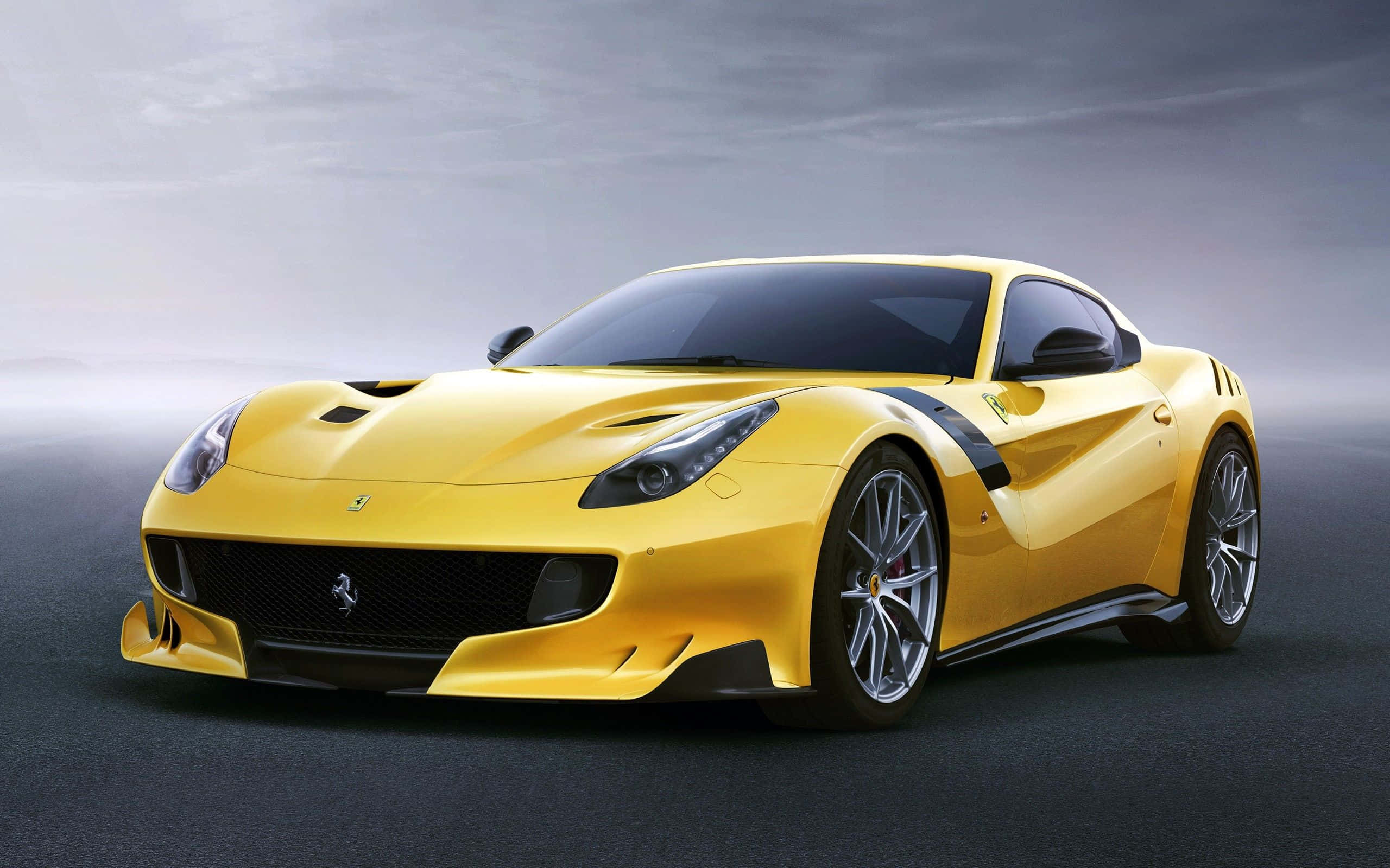 Yellow Car 桌布 壁紙 — 一輛充滿活力的黃色法拉利跑車，帶有黑色點綴，在霧灰色背景下，在戲劇性的工作室燈光下閃閃發光。