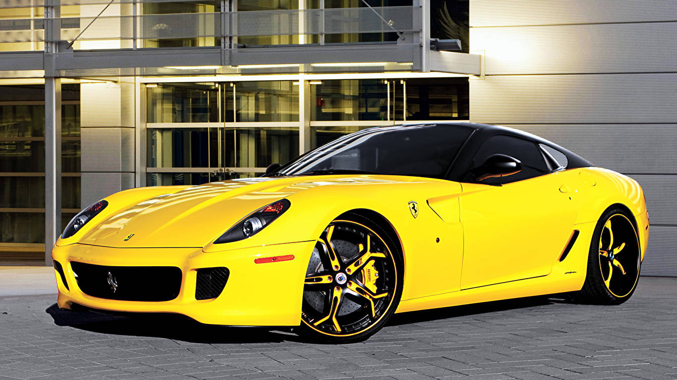 Sports Car 桌布 壁紙 — 一輛充滿活力的黃色法拉利跑車停泊在現代玻璃建築前的鋪砌地面上。