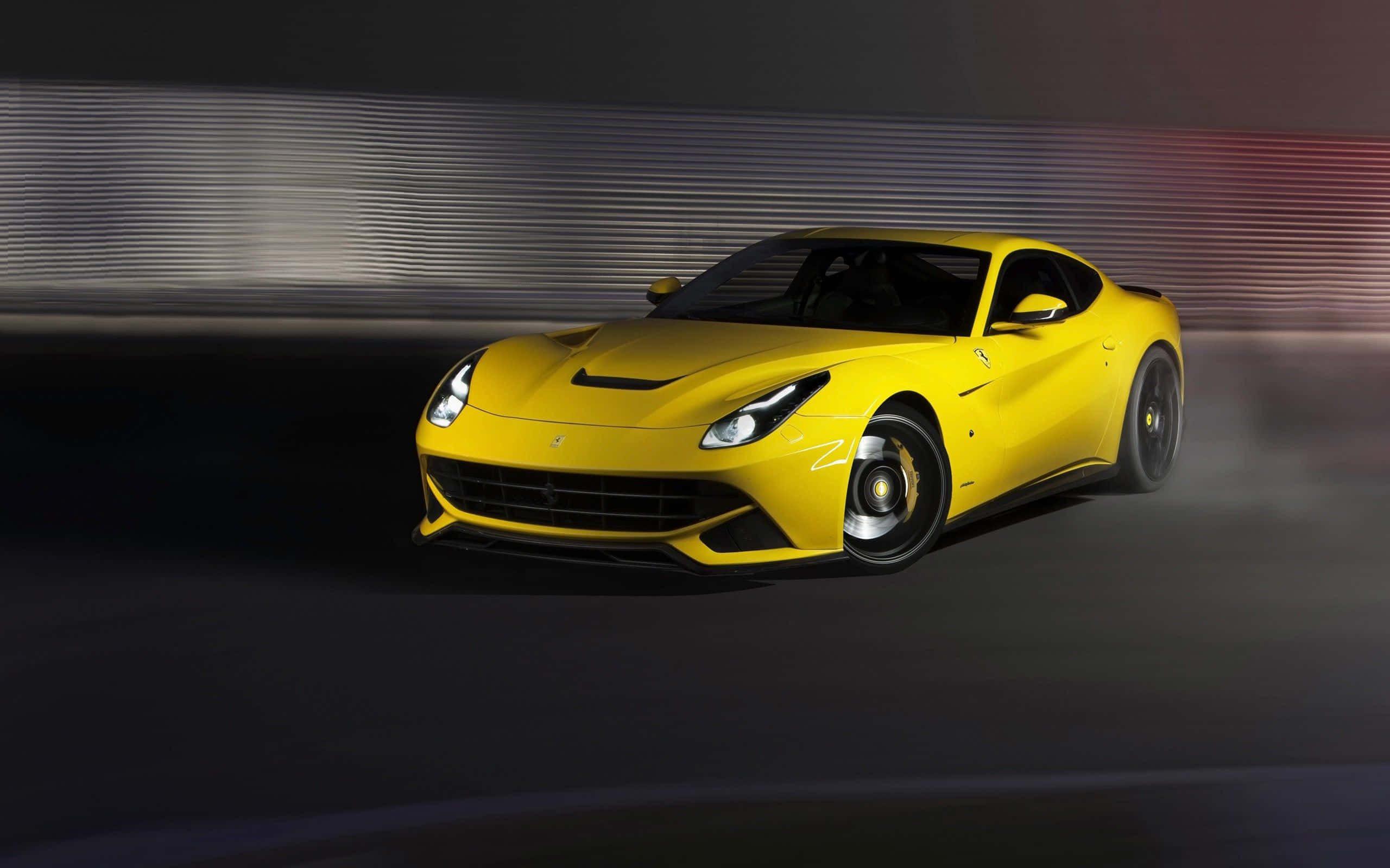Yellow Car 桌布 壁紙 — 一輛充滿活力的黃色法拉利跑車在黑暗的賽道上疾馳，背景帶有動態模糊的痕跡。