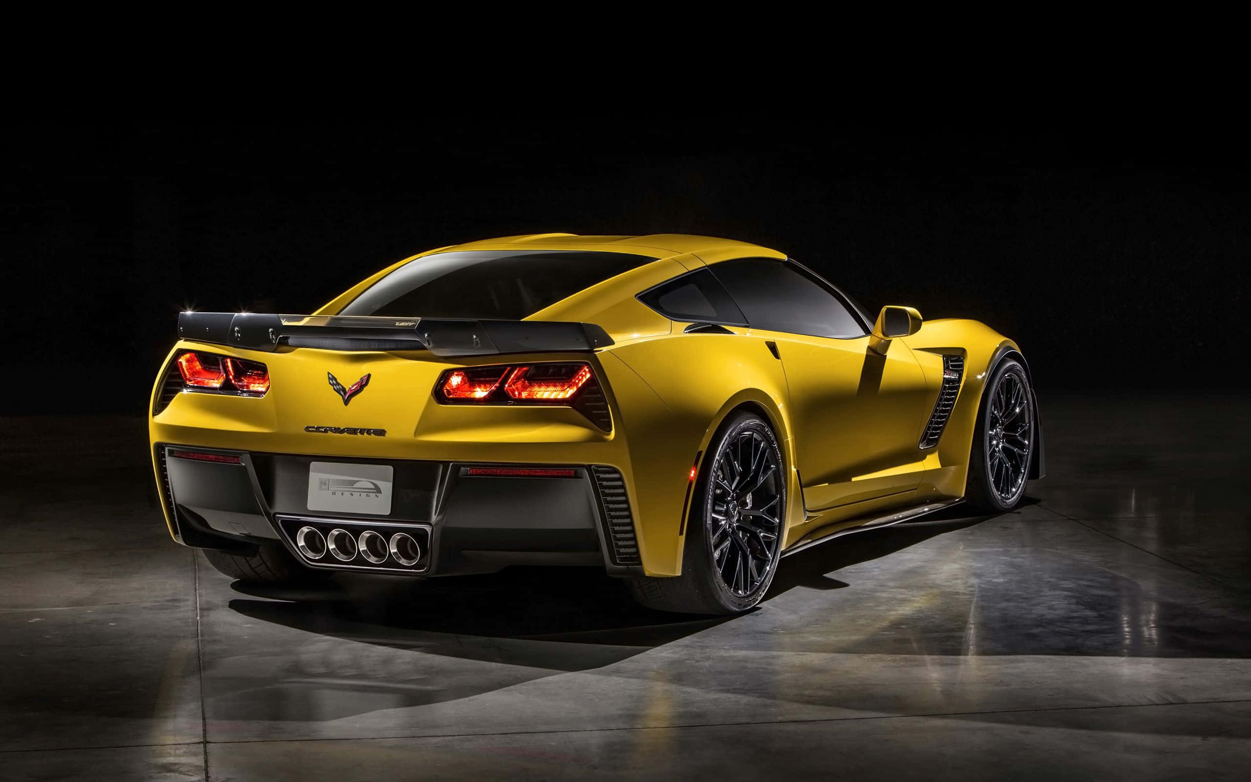 Chevrolet Corvette Z06 桌布 壁紙 — 一輛充滿活力的黃色雪佛蘭克爾維特跑車在黑暗背景下的攝影棚燈光中閃閃發光。