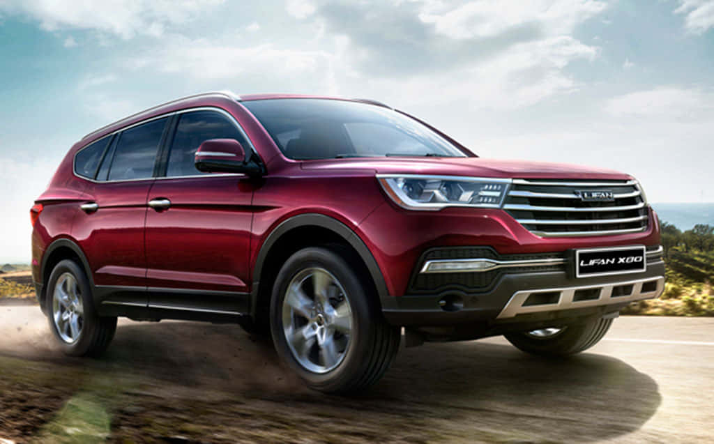 Lifan 桌布 壁紙 — 一輛光亮的紅色力帆X80 SUV在陰天、遠山背景下，於泥路上動態行駛。