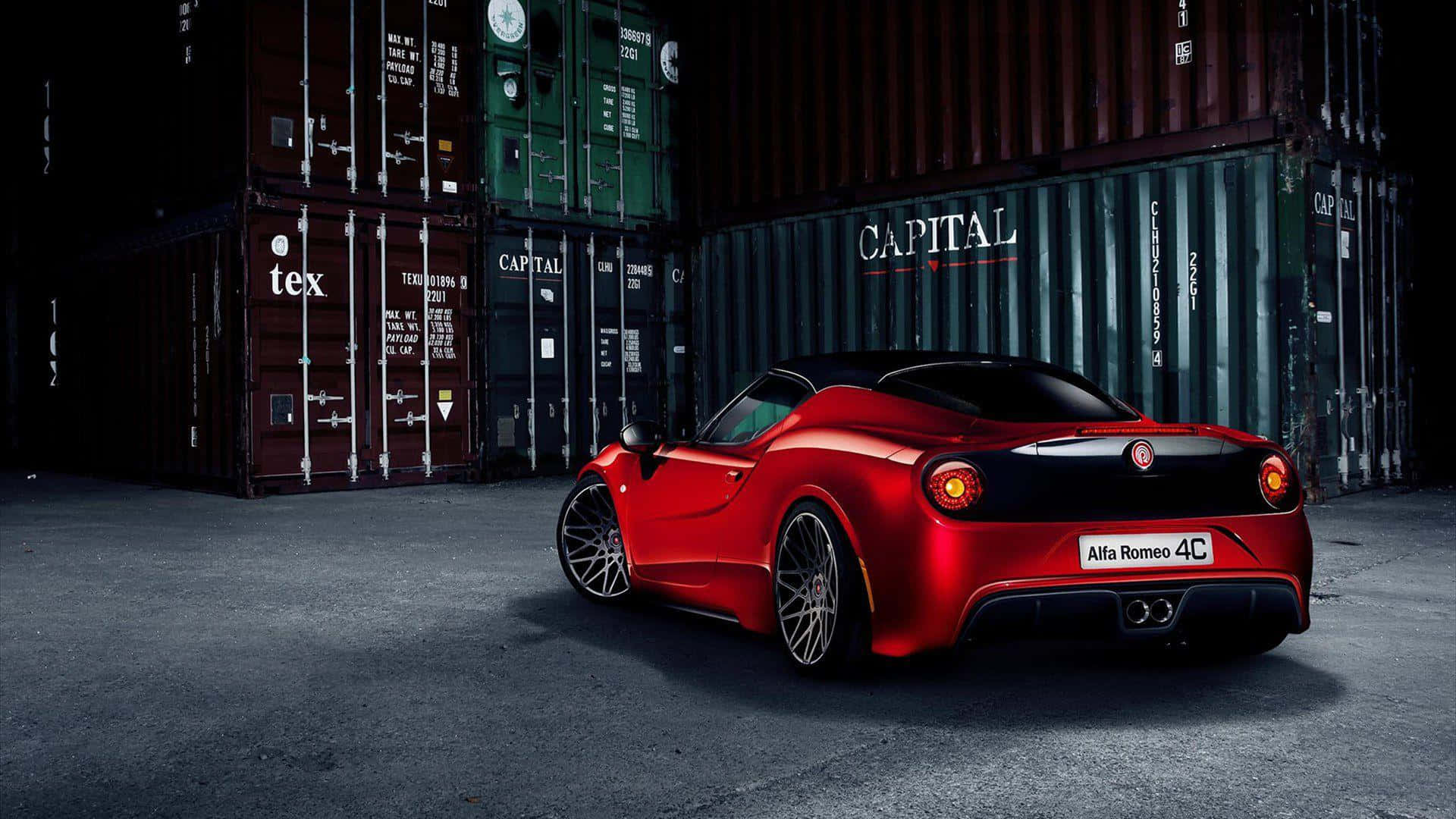 Alfa Romeo 4c 桌布 壁紙 — 一輛光亮的紅色愛快羅密歐4C跑車停放在堆疊的貨運集裝箱之間，在戲劇性的燈光下。