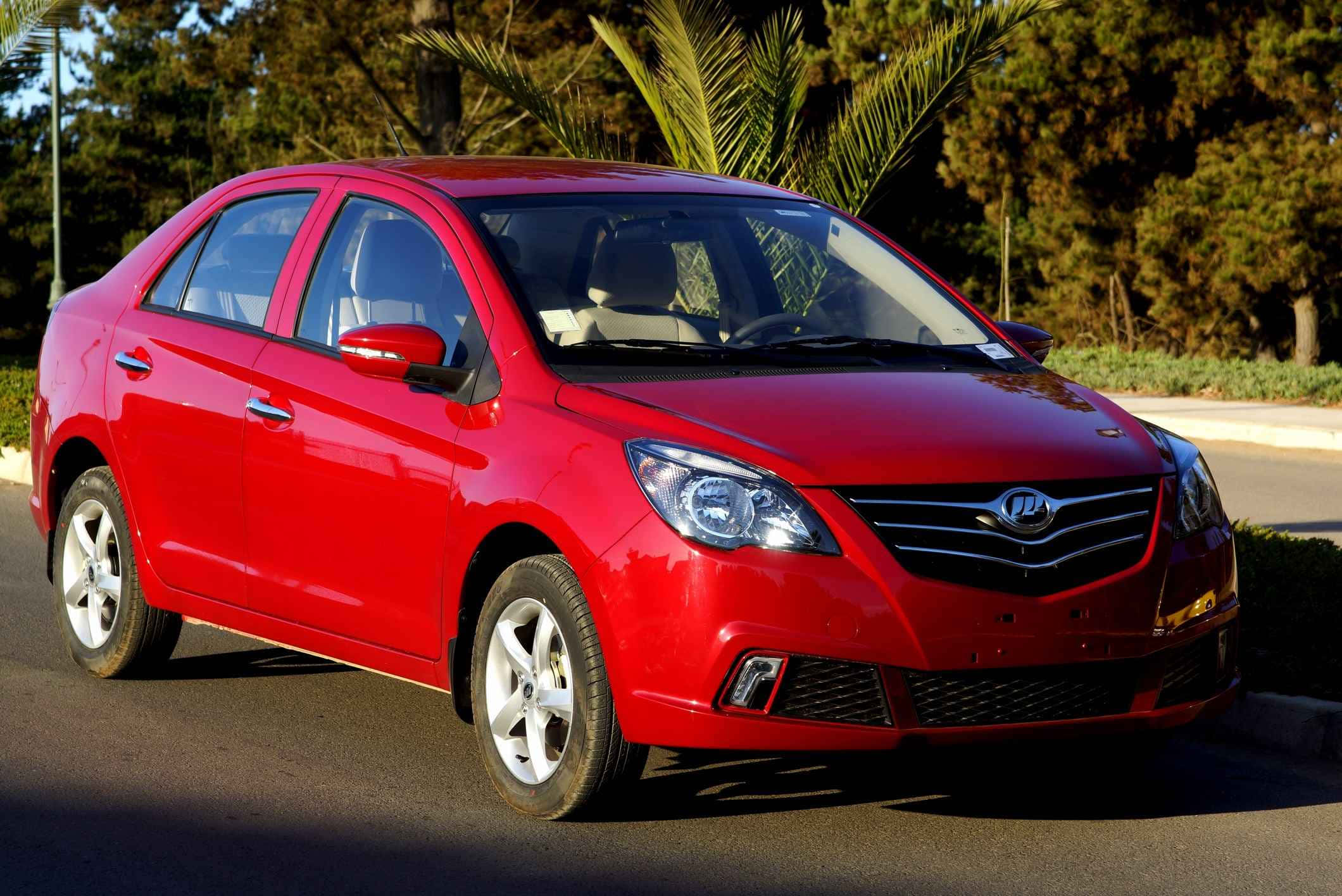 Lifan 桌布 壁紙 — 一輛光亮的紅色房車停泊在陽光普照的街道上，背景有棕櫚樹和綠植。