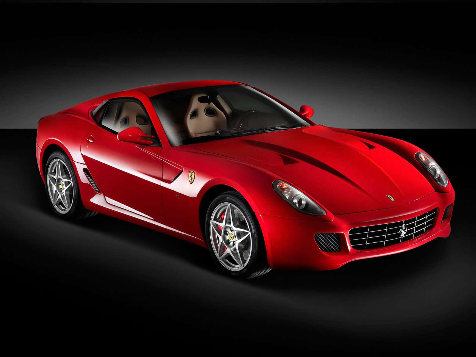 Ferrari 599 Gtb Fiorano 桌布 壁紙 — 一輛光亮的紅色法拉利跑車，配備銀色輪圈和米色內飾，在深色漸變背景前展示。