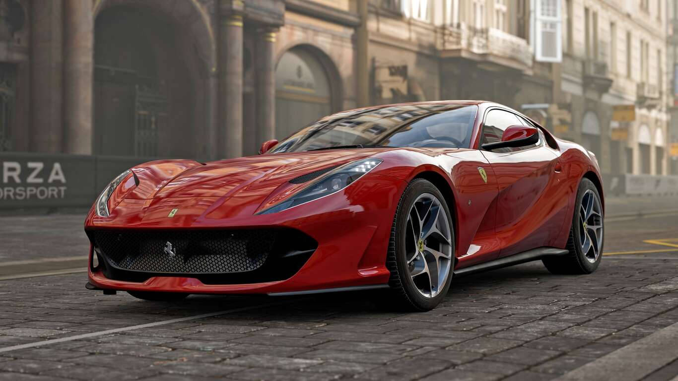 Sports Car 桌布 壁紙 — 一輛光亮的紅色法拉利跑車停在鵝卵石街道上，背景是歷史建築。