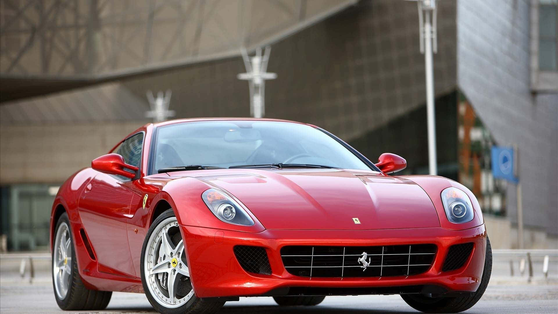 Ferrari 599 Gtb Fiorano 桌布 壁紙 — 一輛光亮的紅色法拉利跑車停泊在現代混凝土建築前，建築線條銳利。