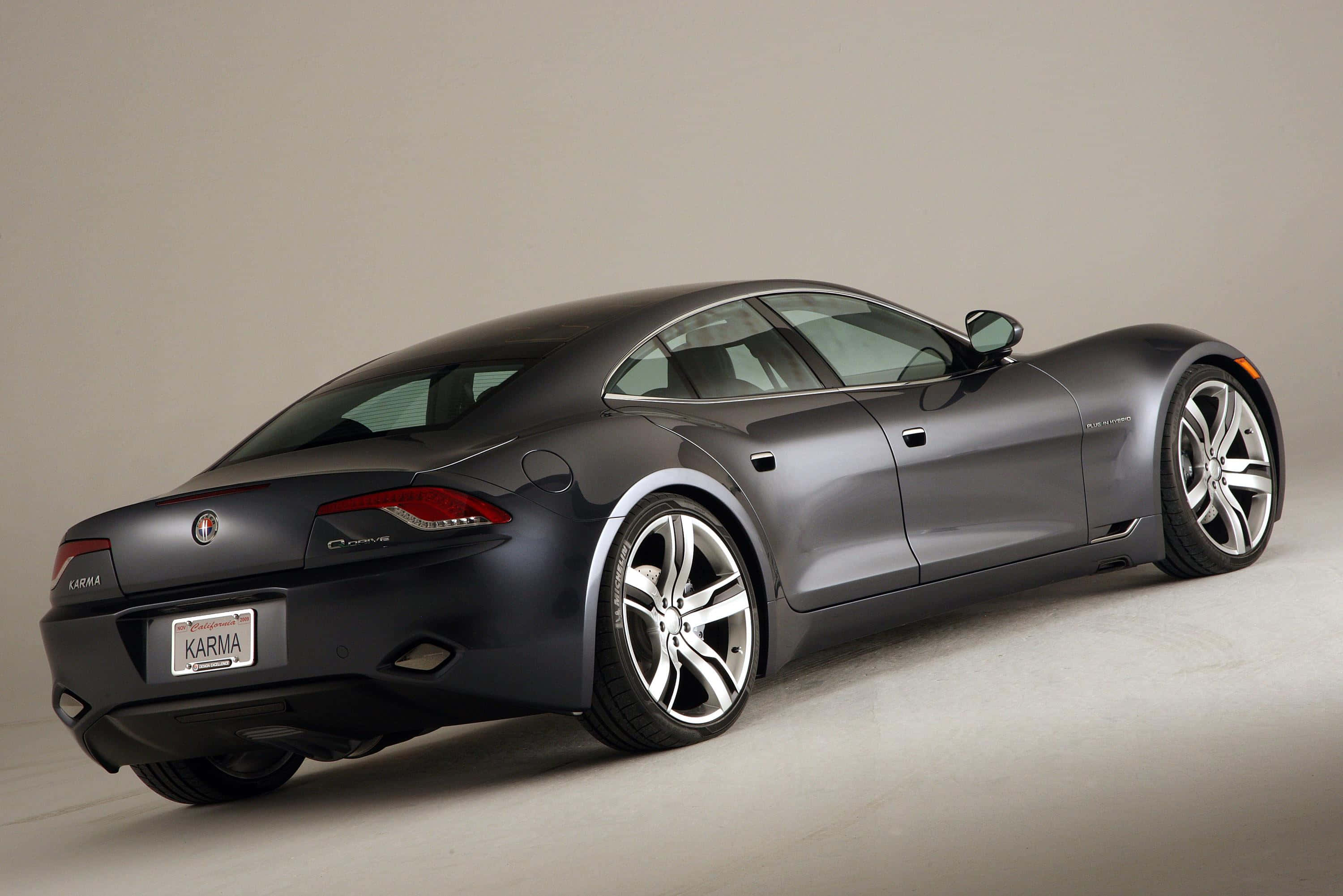 Fisker 桌布 壁紙 — 一輛光滑的啞光灰色Karma跑車在攝影棚內拍攝，柔和的光線突顯其空氣動力學曲線和銀色合金輪圈。