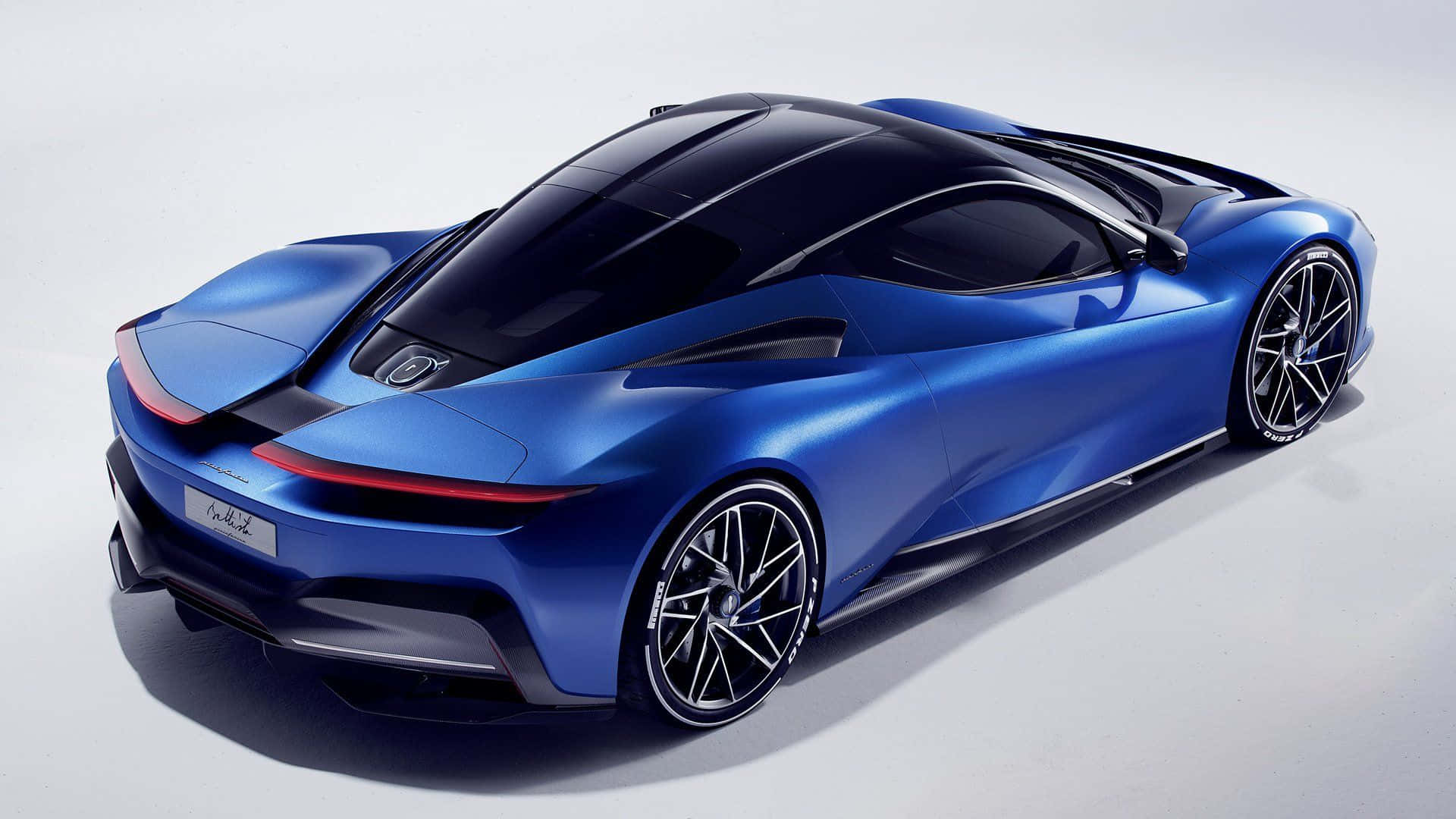 Pininfarina 桌布 壁紙 — 一輛光滑的藍色跑車，帶有光澤飾面和黑色點綴，從後方四分之三角度展示在純白色背景上。