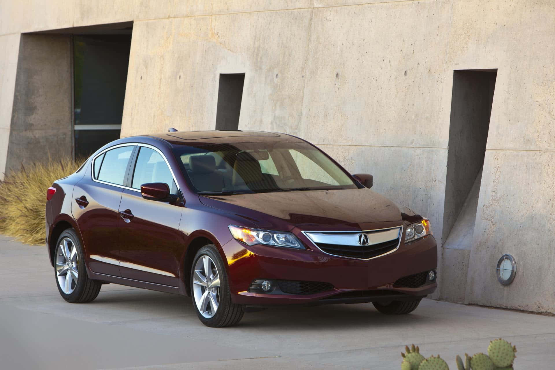 Acura Ilx 桌布 壁紙 — 一輛光澤的栗色轎車停在一棟現代混凝土建築旁邊，附近有沙漠仙人掌。