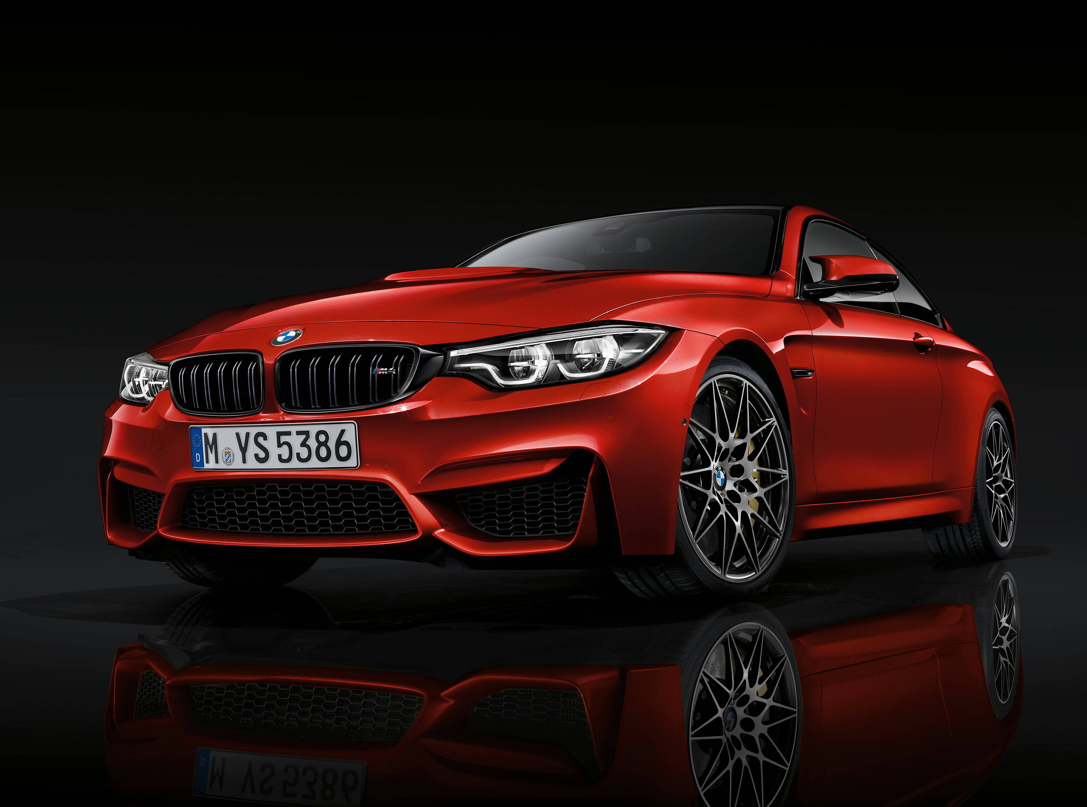 Sports Car 桌布 壁紙 — 一輛光澤的紅色BMW M4雙門轎跑車在攝影棚燈光下閃耀，黑色表面上完美倒映。