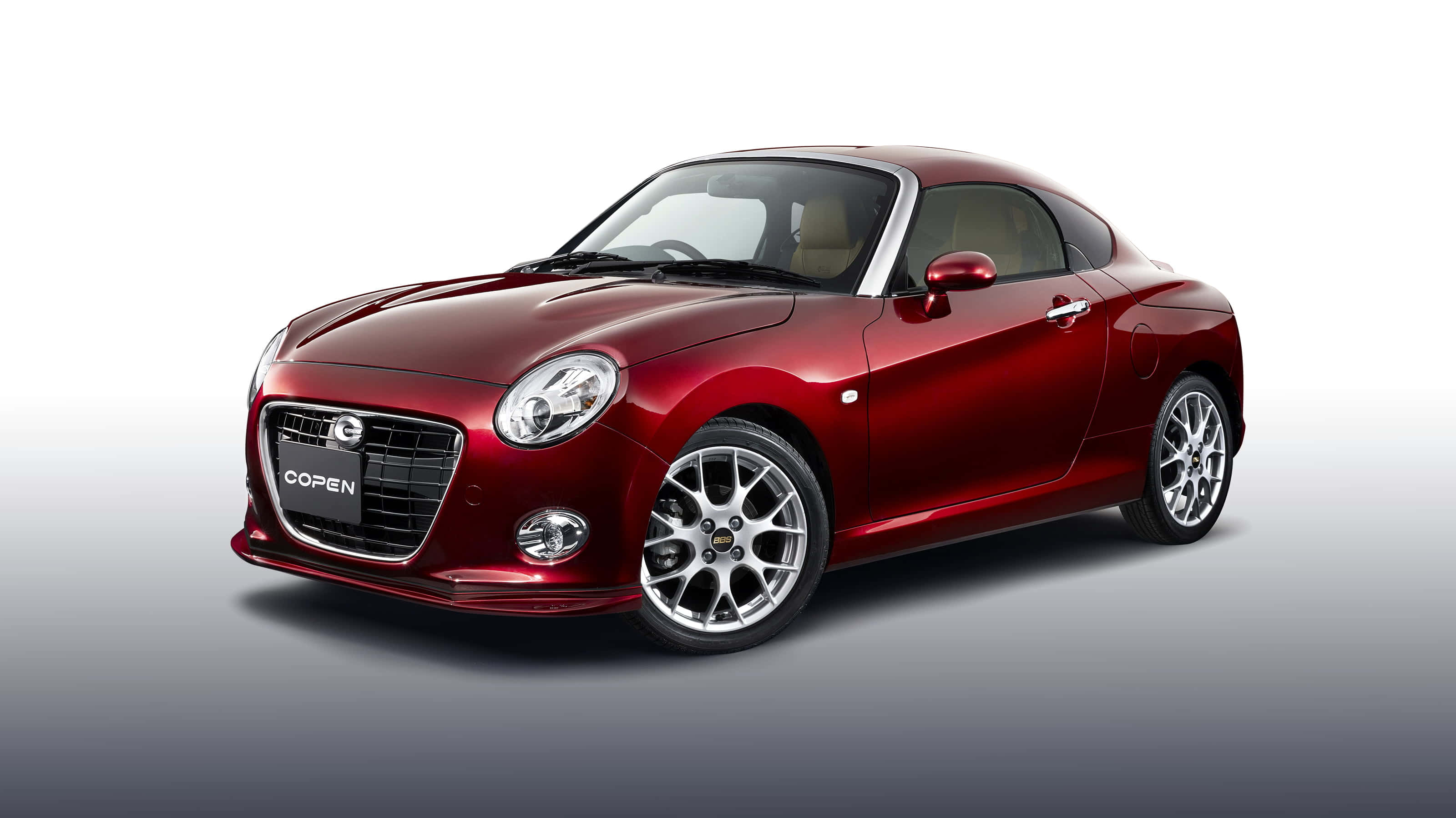 Daihatsu 桌布 壁紙 — 一輛光澤的紅色Mazda Copen跑車配銀色輪圈，在漸變灰色背景的攝影棚中展示。