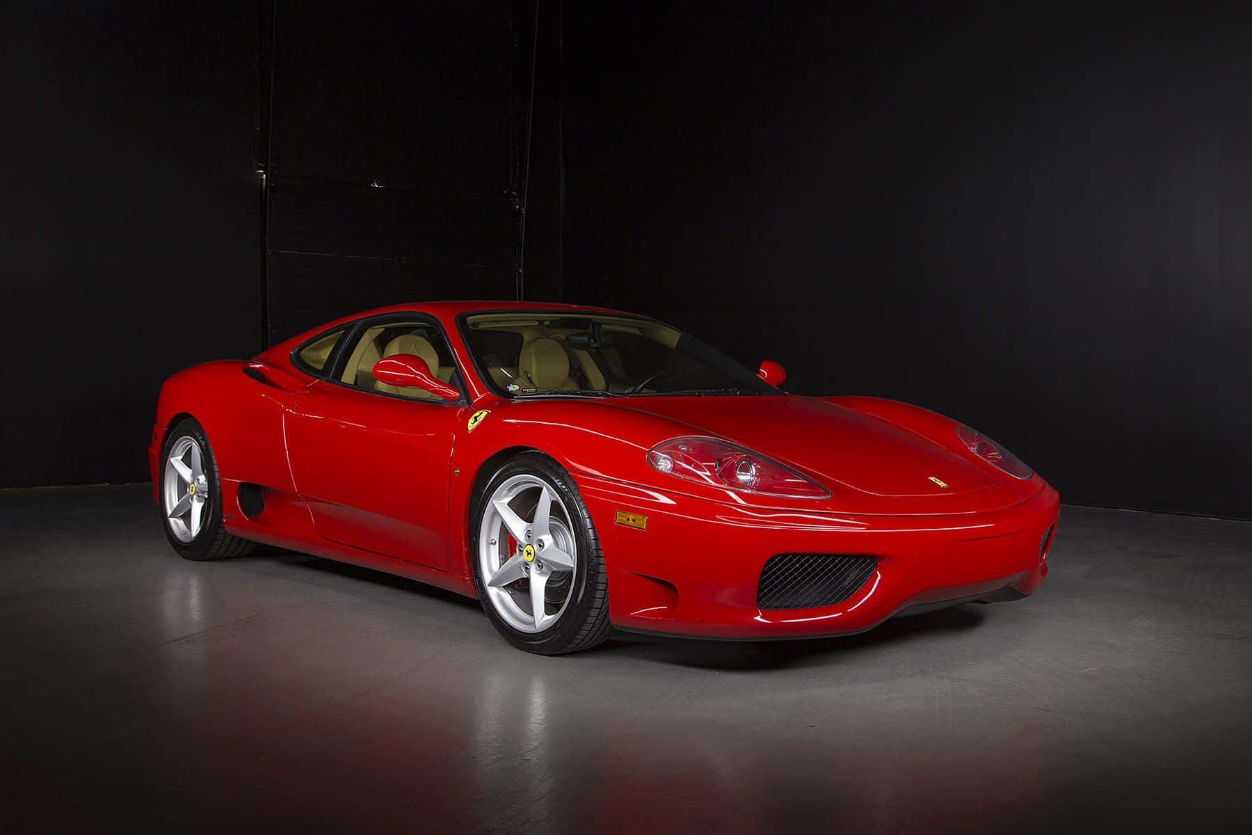 Ferrari 360 Modena 桌布 壁紙 — 一輛光澤的紅色法拉利360跑車在攝影棚燈光下，在黑色背景上閃閃發光。