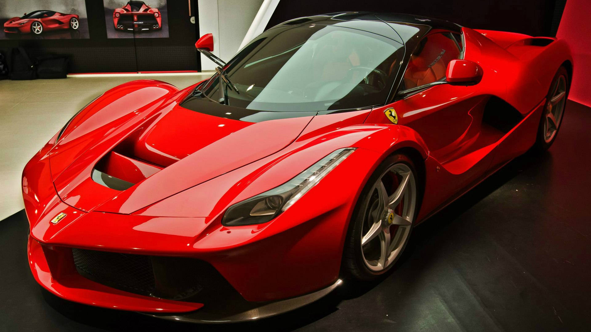 Sports Car 桌布 壁紙 — 一輛光澤的紅色法拉利LaFerrari超級跑車在明亮的燈光下閃耀，位於時尚現代的展廳。