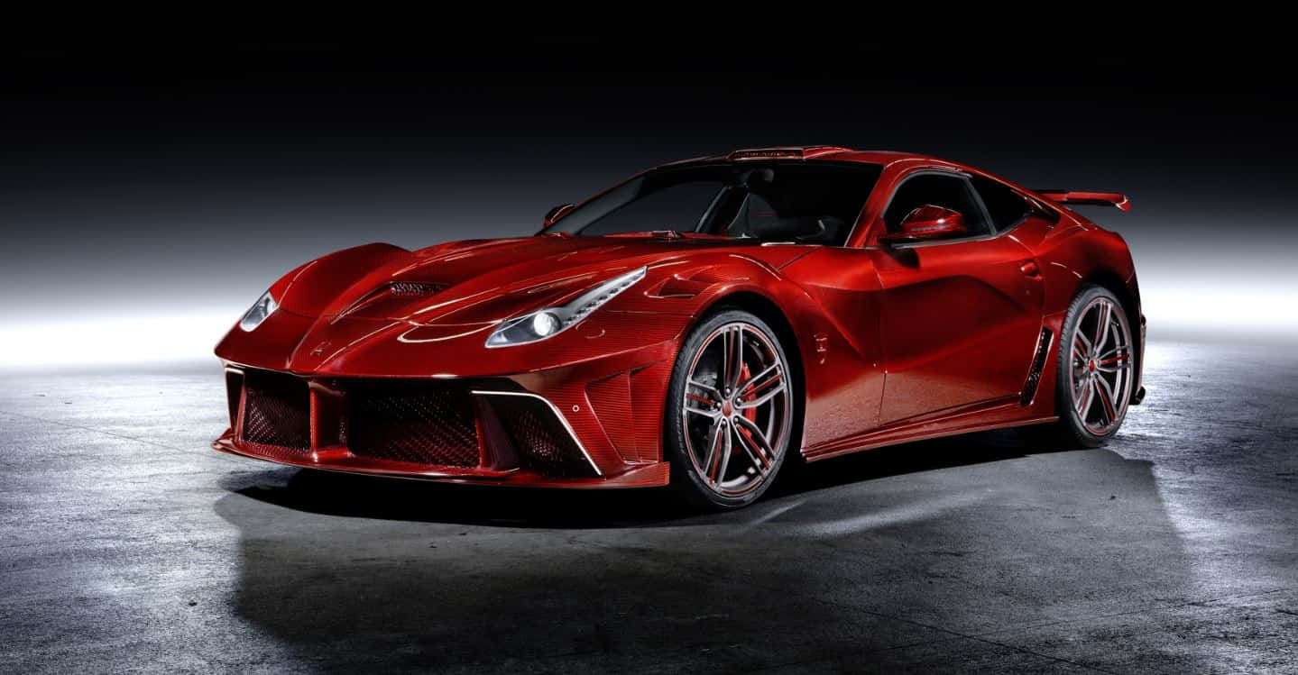 Ferrari F12 Berlinetta 桌布 壁紙 — 一輛光澤的紅色法拉利跑車在黑暗的混凝土地板上，在戲劇性的工作室燈光下閃閃發光。