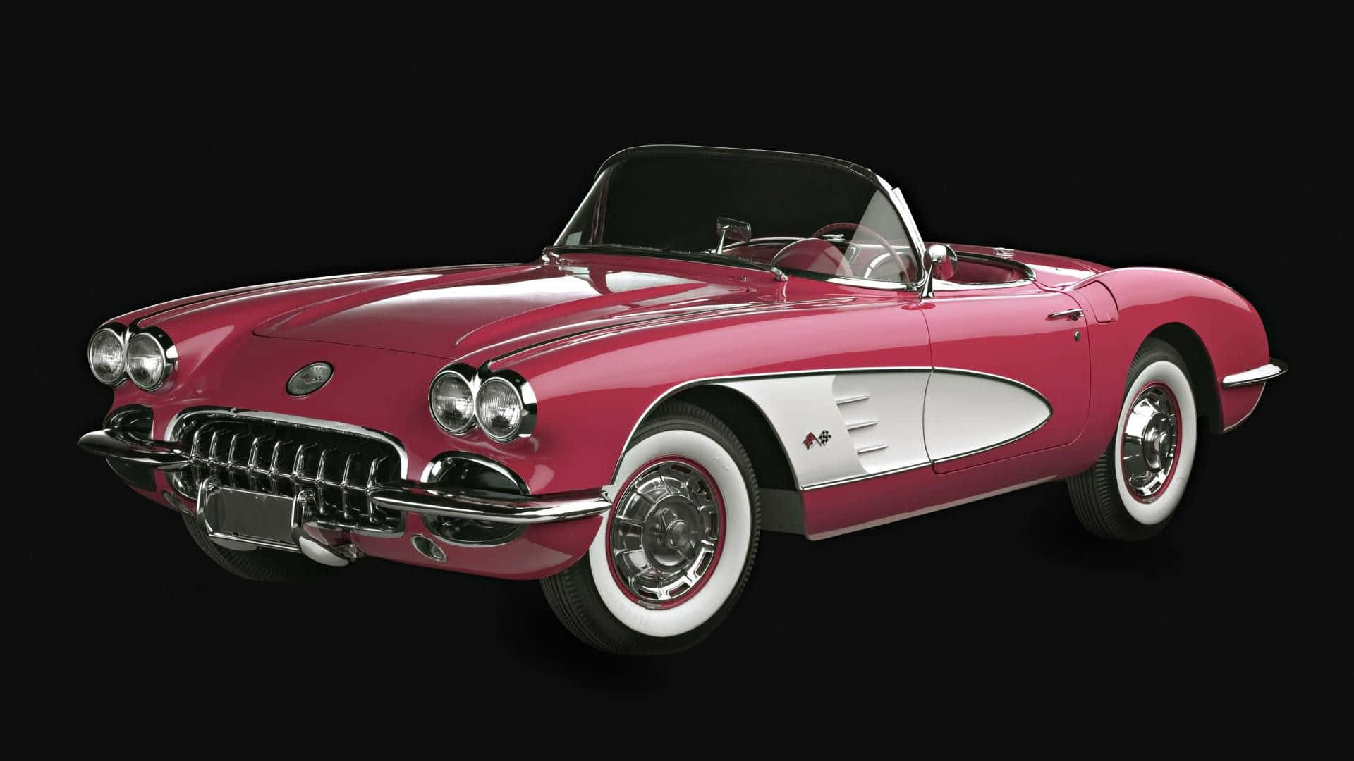 classic 桌布 壁紙 — 一輛光澤粉紅色的 1960 年代雪佛蘭 Corvette 敞篷車，帶有白色賽車條紋和白牆輪胎，在純黑色背景下脫穎而出。