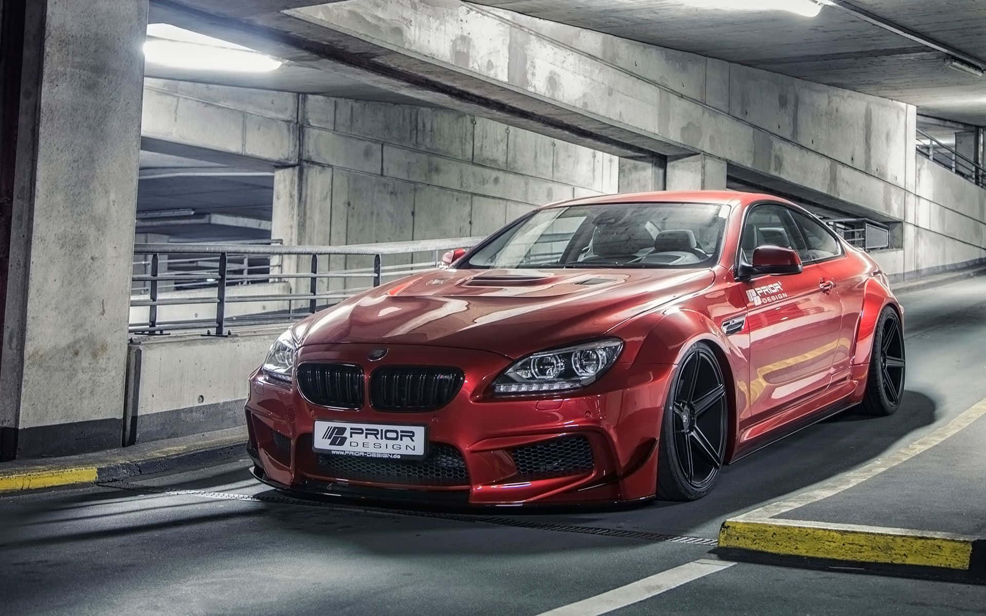 Bmw 6 Series 桌布 壁紙 — 一輛光澤紅色改裝BMW M6雙門跑車停放在混凝土地下停車場，帶有戲劇性燈光。