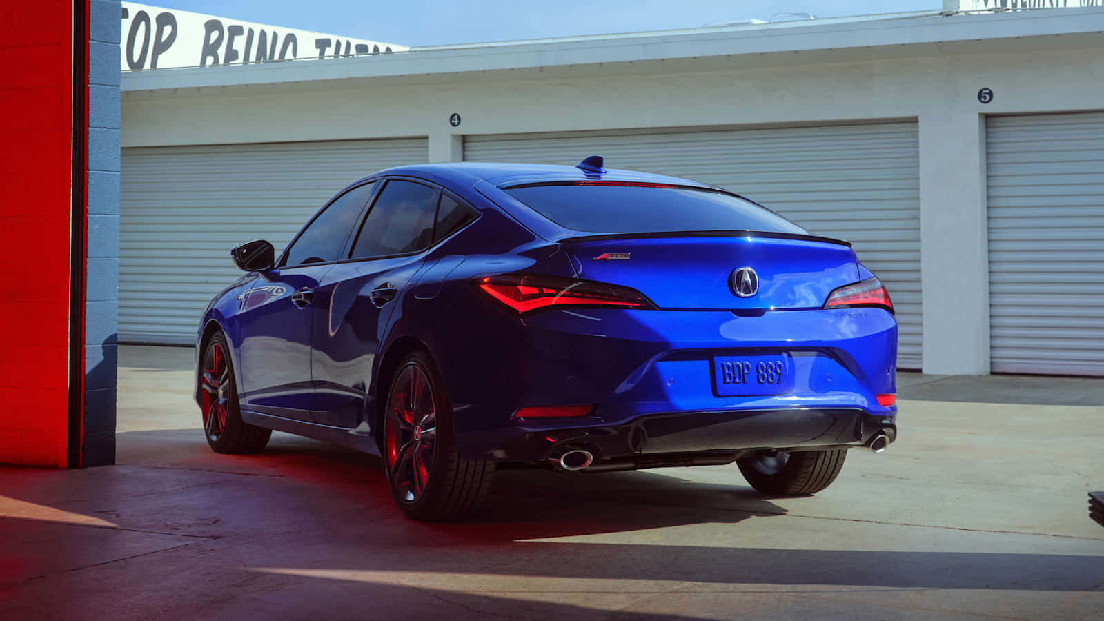 Acura Integra 桌布 壁紙 — 一輛光澤藍色Acura TLX運動轎車停在車庫前，紅色燈光投射出戲劇性的陰影。