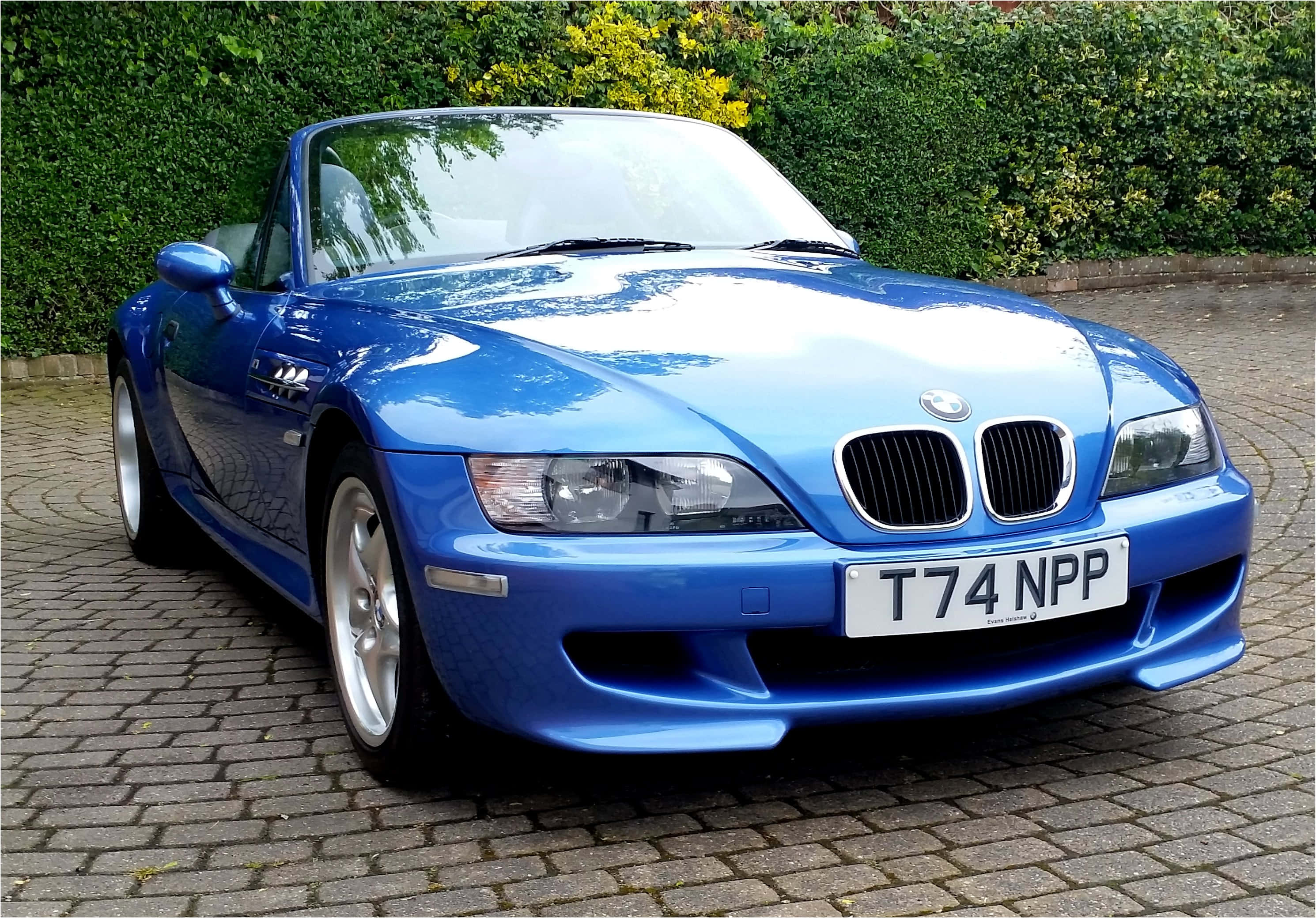 Bmw Z3 桌布 壁紙 — 一輛光澤藍色BMW Z8開篷車停泊在鵝卵石車道上，背景有綠色樹籬。