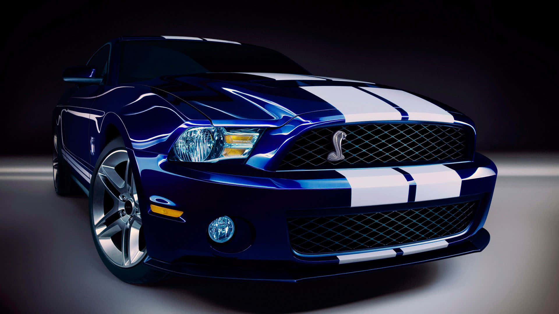 攝影棚燈光下的藍色Shelby Mustang，帶有白色條紋。
