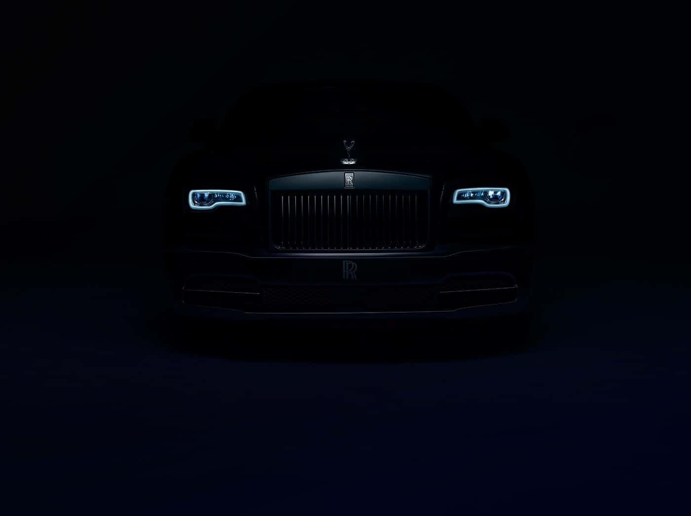 Rolls Royce 桌布 壁紙 — 一輛勞斯萊斯幻影在漆黑一片的虛空中閃耀著銳利的藍色車頭燈，散發出奢華與靜謐的力量。