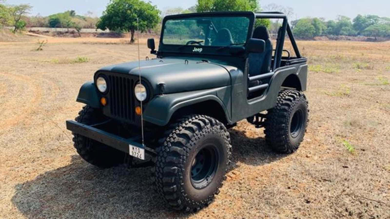 Jeep Cj 桌布 壁紙 — 一輛啞光綠色的經典Jeep Wrangler，配備超大輪胎，停在乾燥的土地上，光線明亮。