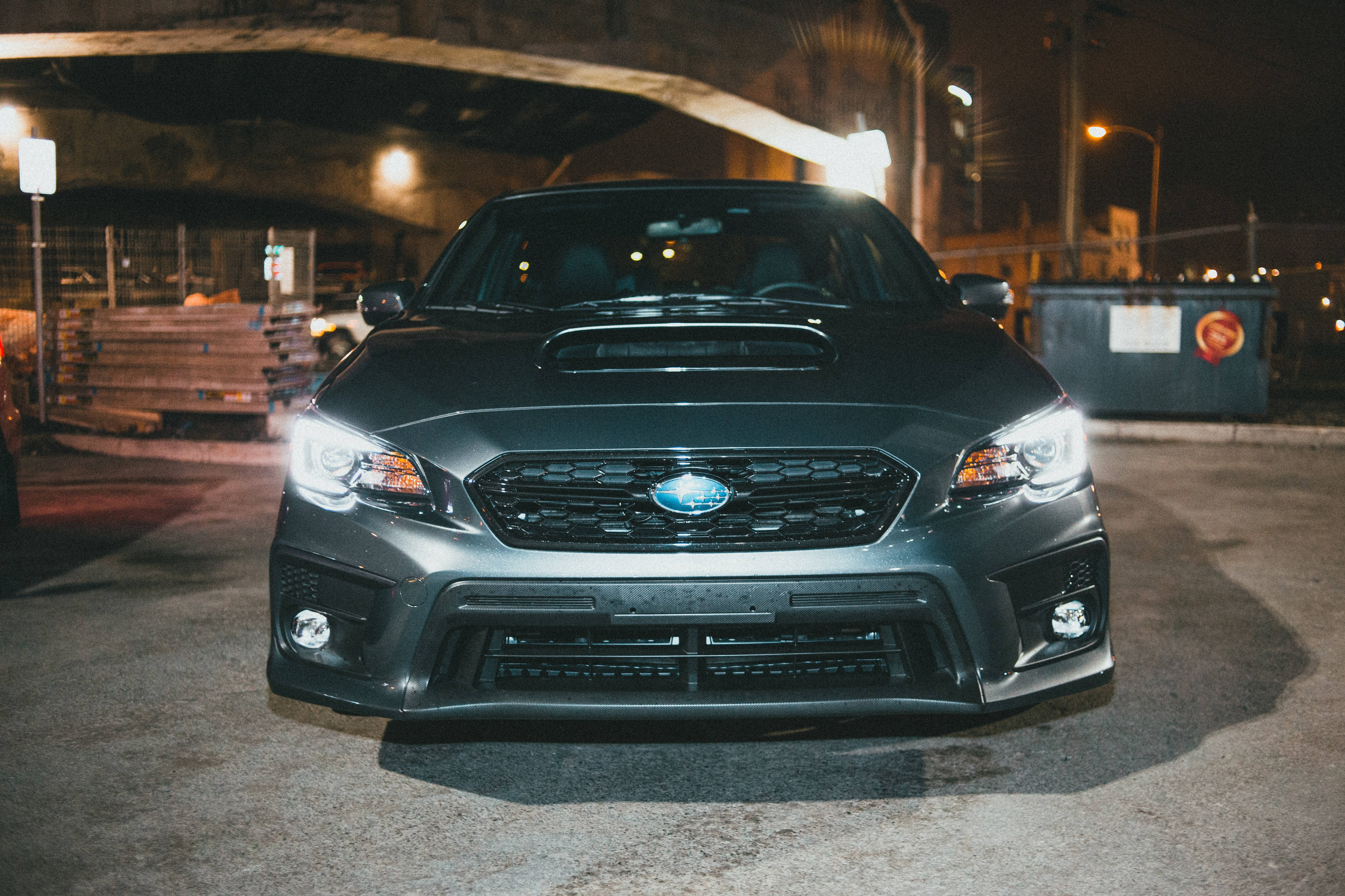 subaru 桌布 壁紙 — 一輛啞光黑色的Subaru WRX STI在夜晚的骯髒城市地下通道中，在街燈下閃閃發光。
