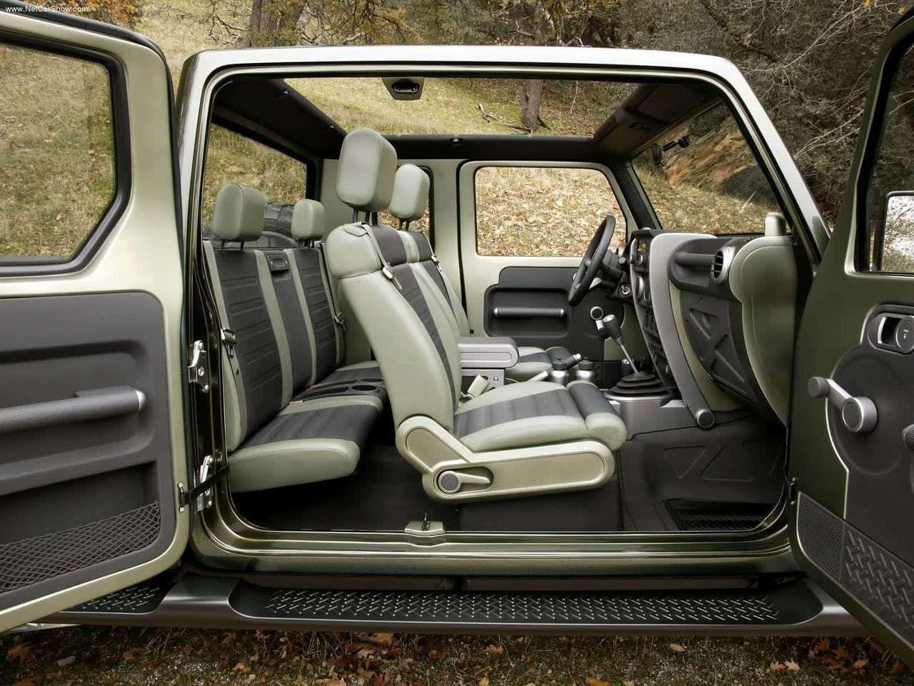 Jeep Gladiator 桌布 壁紙 — 一輛堅固SUV的打開車門，露出其米色和灰色條紋的內部座椅，背景是秋日森林。