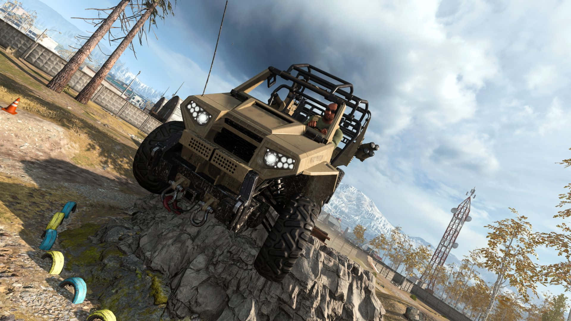Call Of Duty Vehicles 桌布 壁紙 — 一輛堅固的棕褐色越野車在陰天天空下攀爬陡峭的岩石地形，遠處有積雪的山峰和稀疏的樹木。